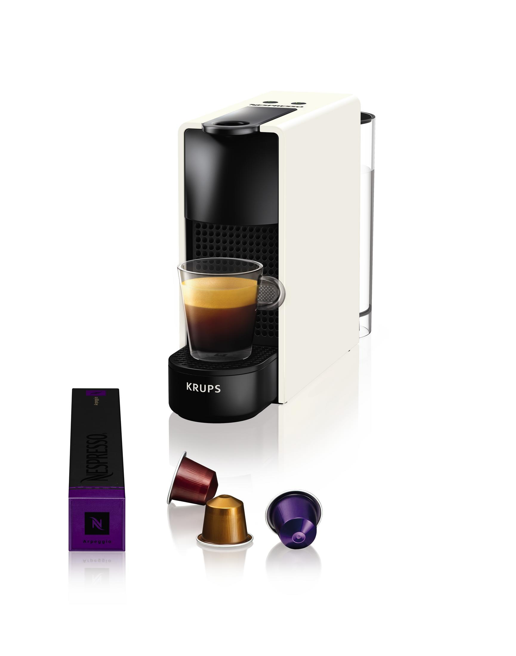 Macchina da caffè Krups Nespresso con capsule e un bicchiere di espresso su sfondo bianco.