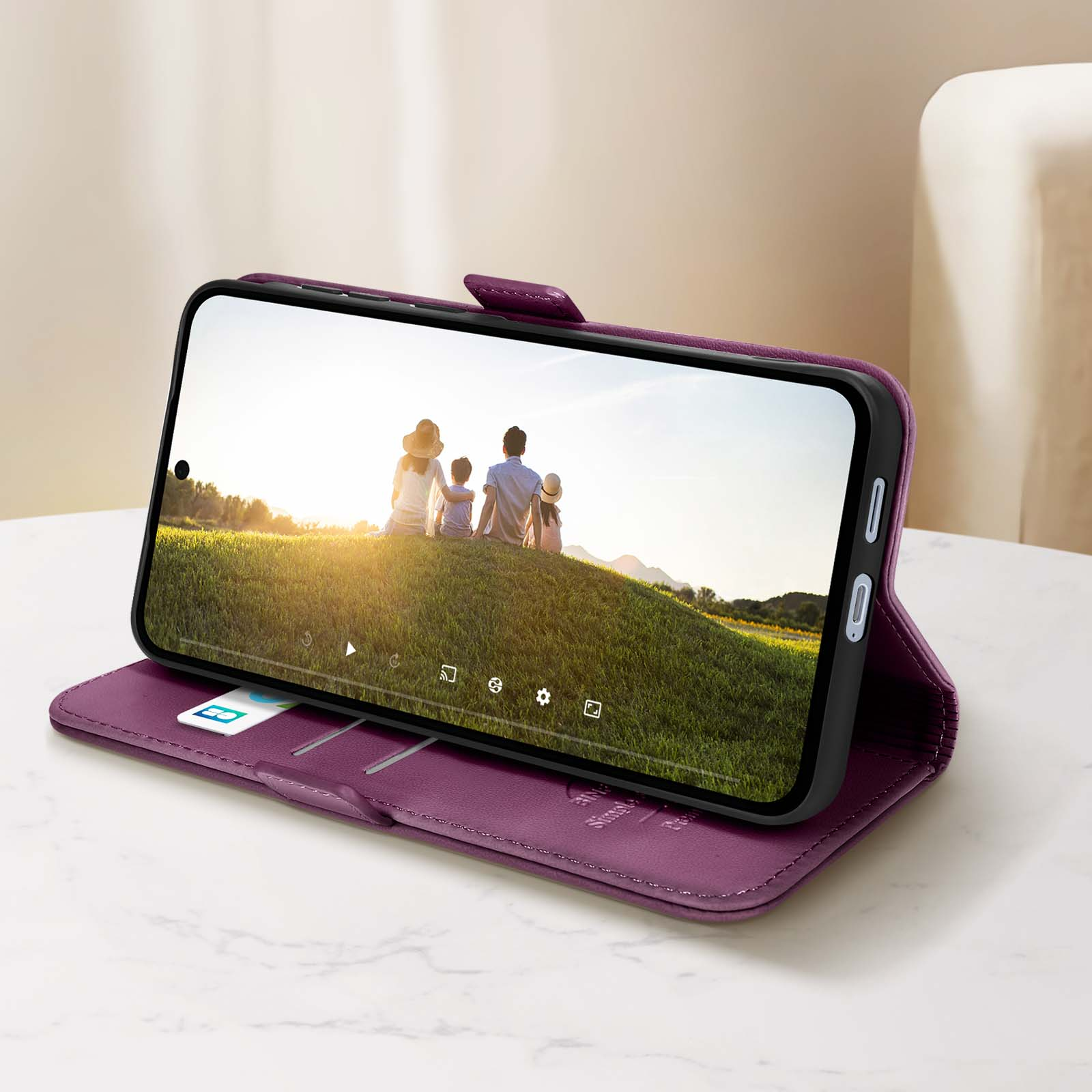 Un telefono in una custodia viola che mostra una foto di famiglia con il sole.
