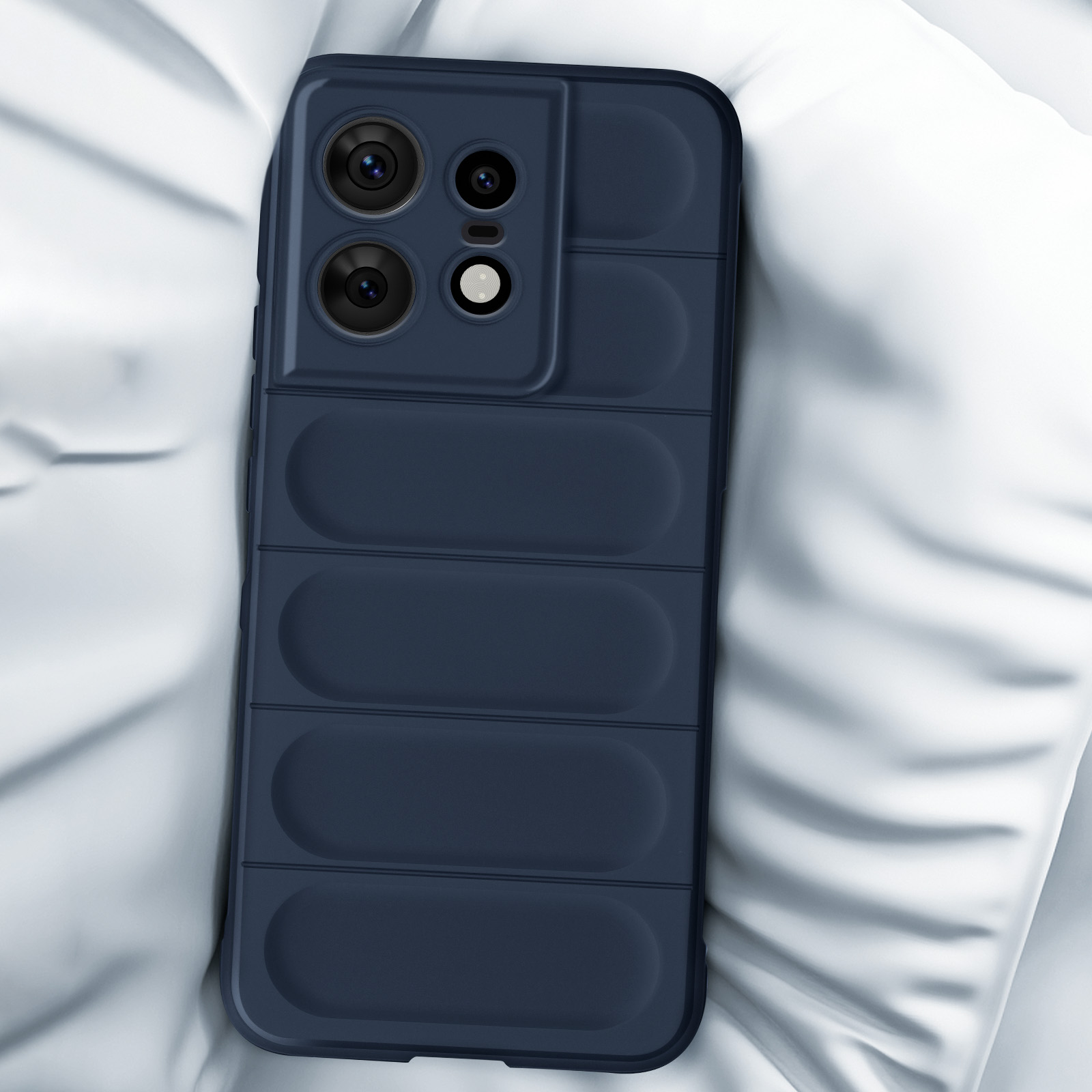 Custodia blu scuro con modulo fotocamera su un cuscino bianco.