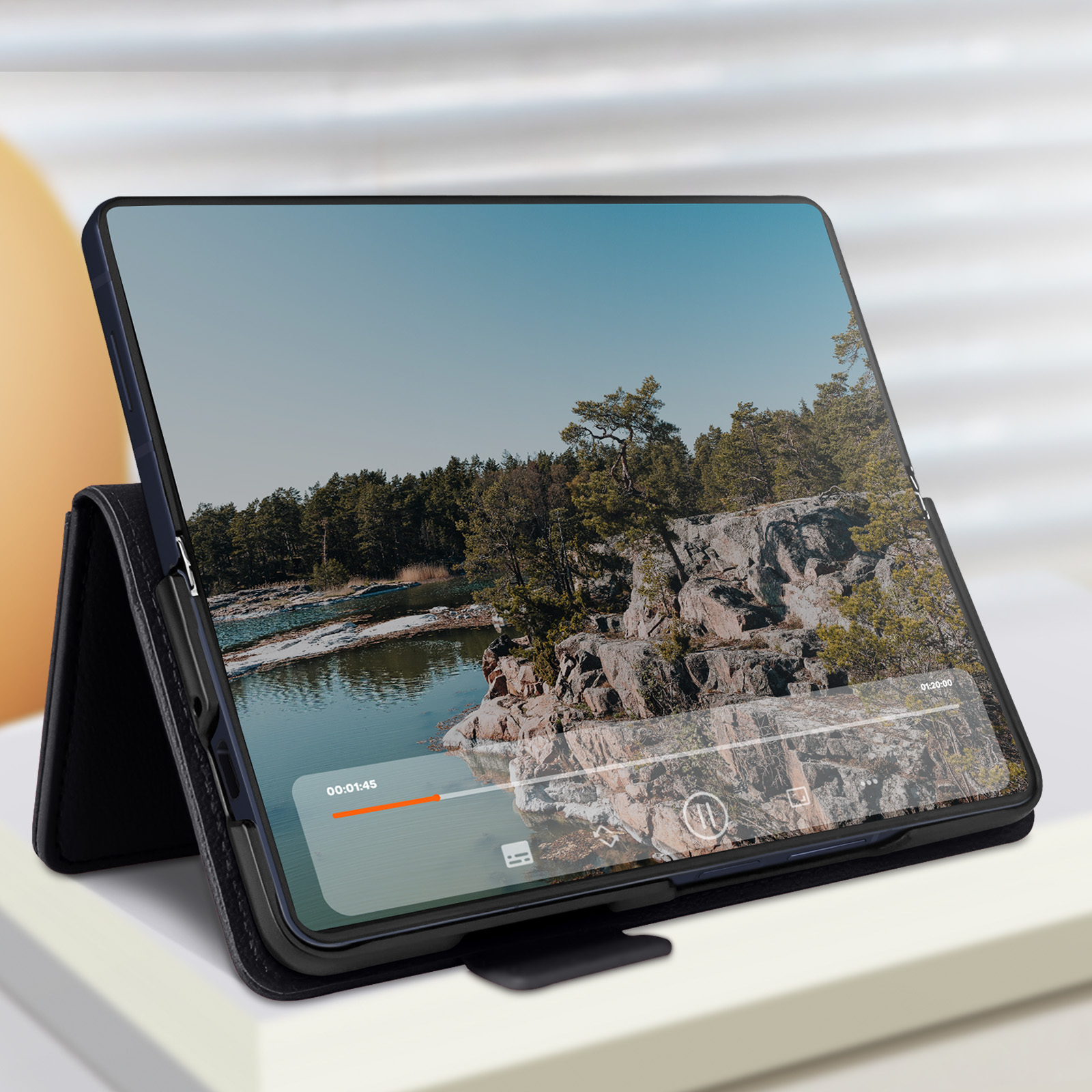 Tablet su supporto che mostra un video. La scena mostra una foresta e un lago con cielo blu.