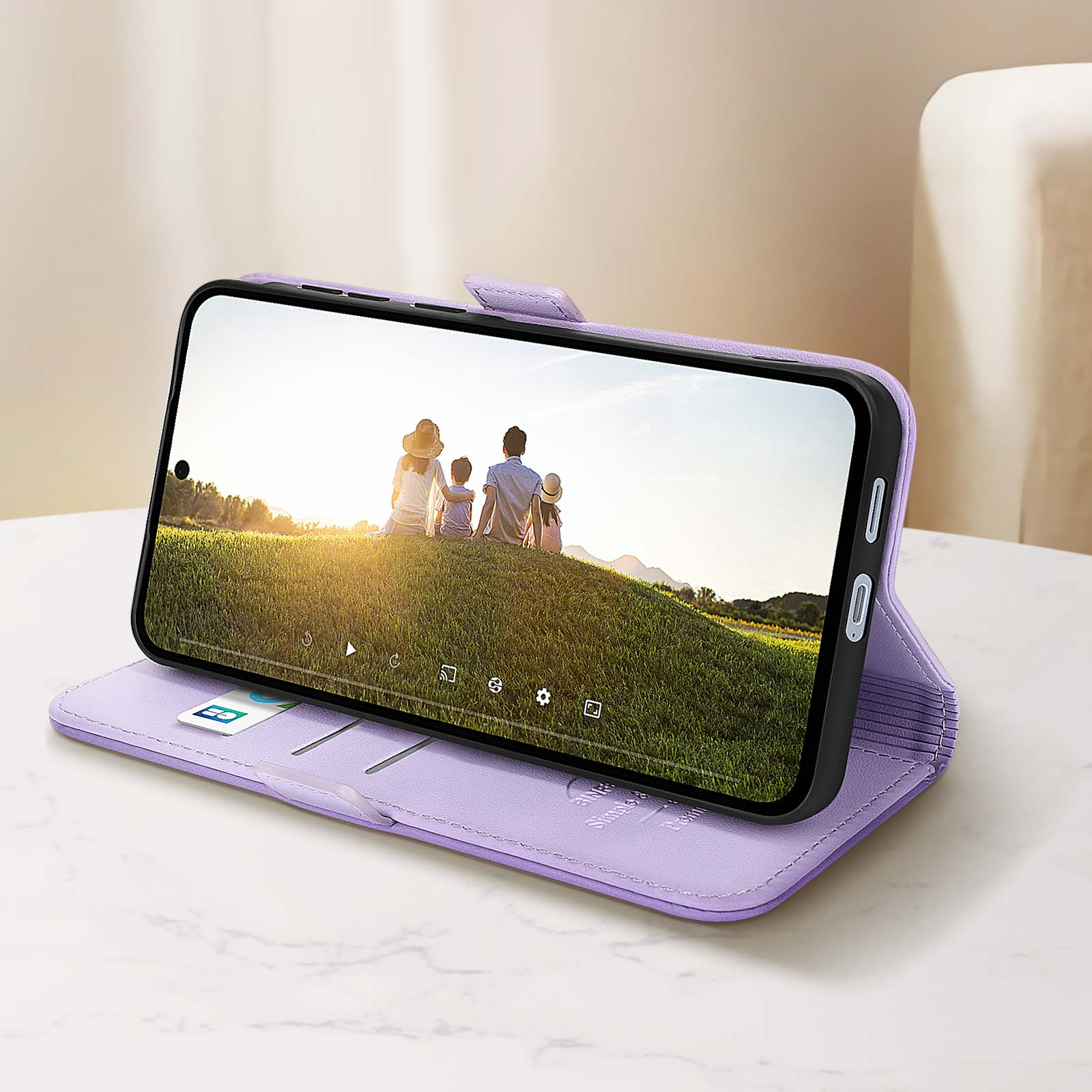 Custodia viola per telefono con foto di famiglia. Sfondo tavolo bianco.
