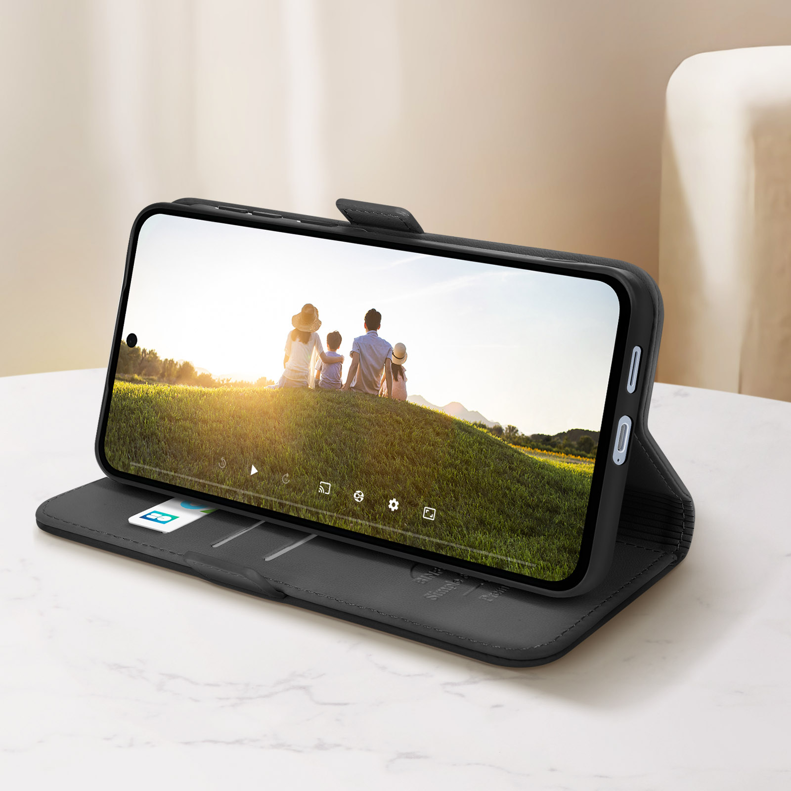 Telefono in una custodia a libro, che mostra una foto di famiglia sullo schermo. Custodia su una superficie di marmo.