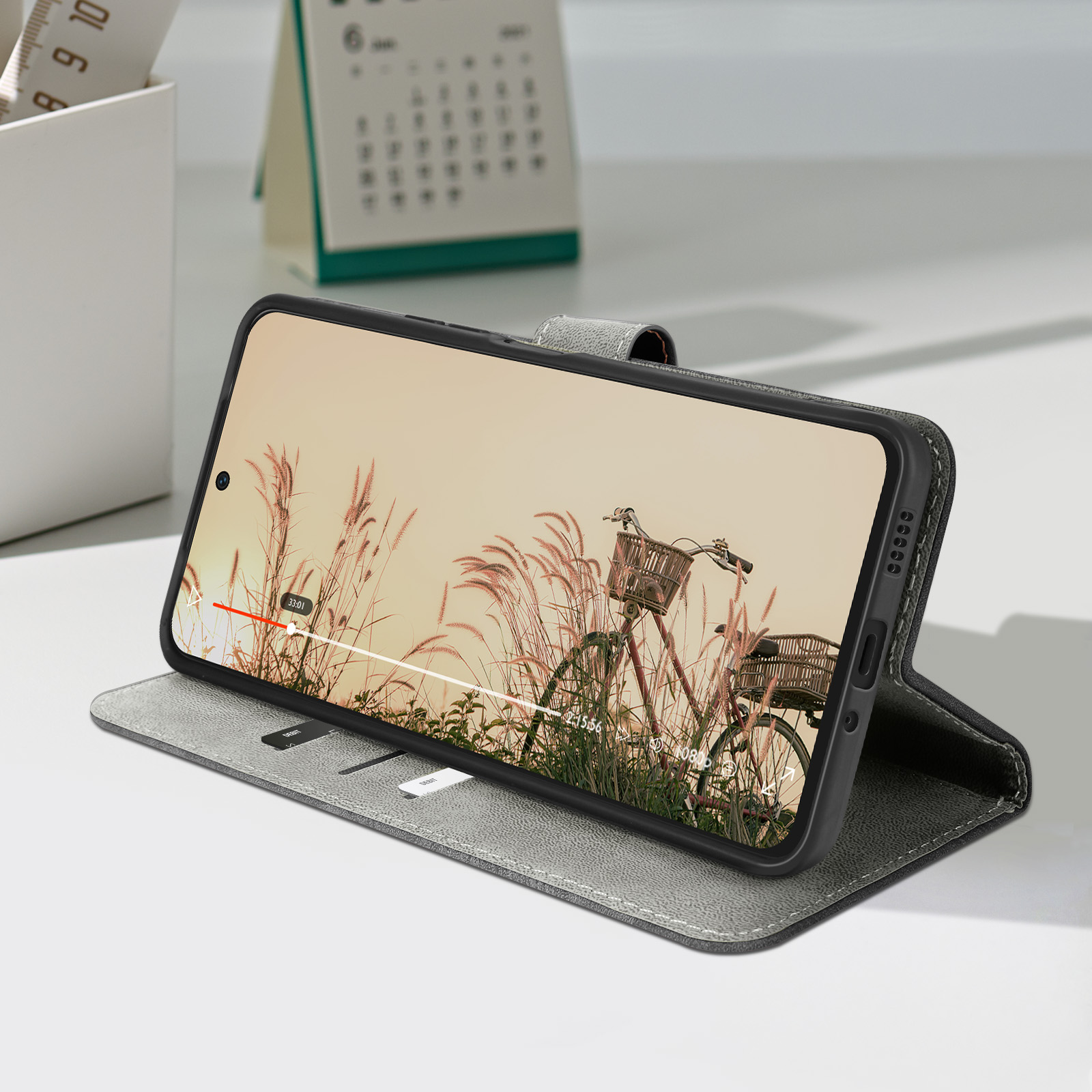 Graue Handyhülle, mit einem Telefon, das ein Fahrradvideo zeigt.