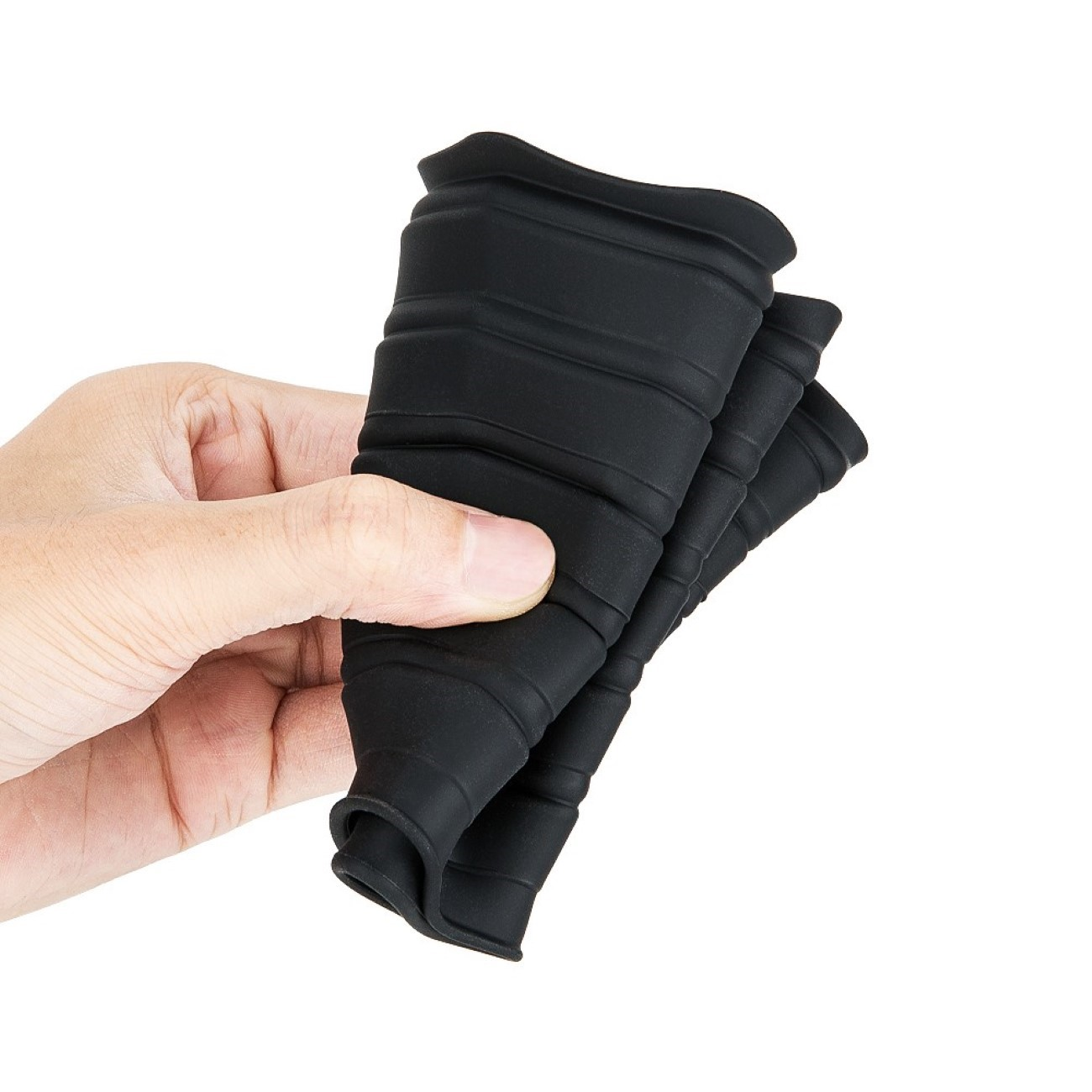 Eine Hand hält eine schwarze Gummi-Objektiv-Gegenlichtblende, zu einer Kegelform gefaltet.