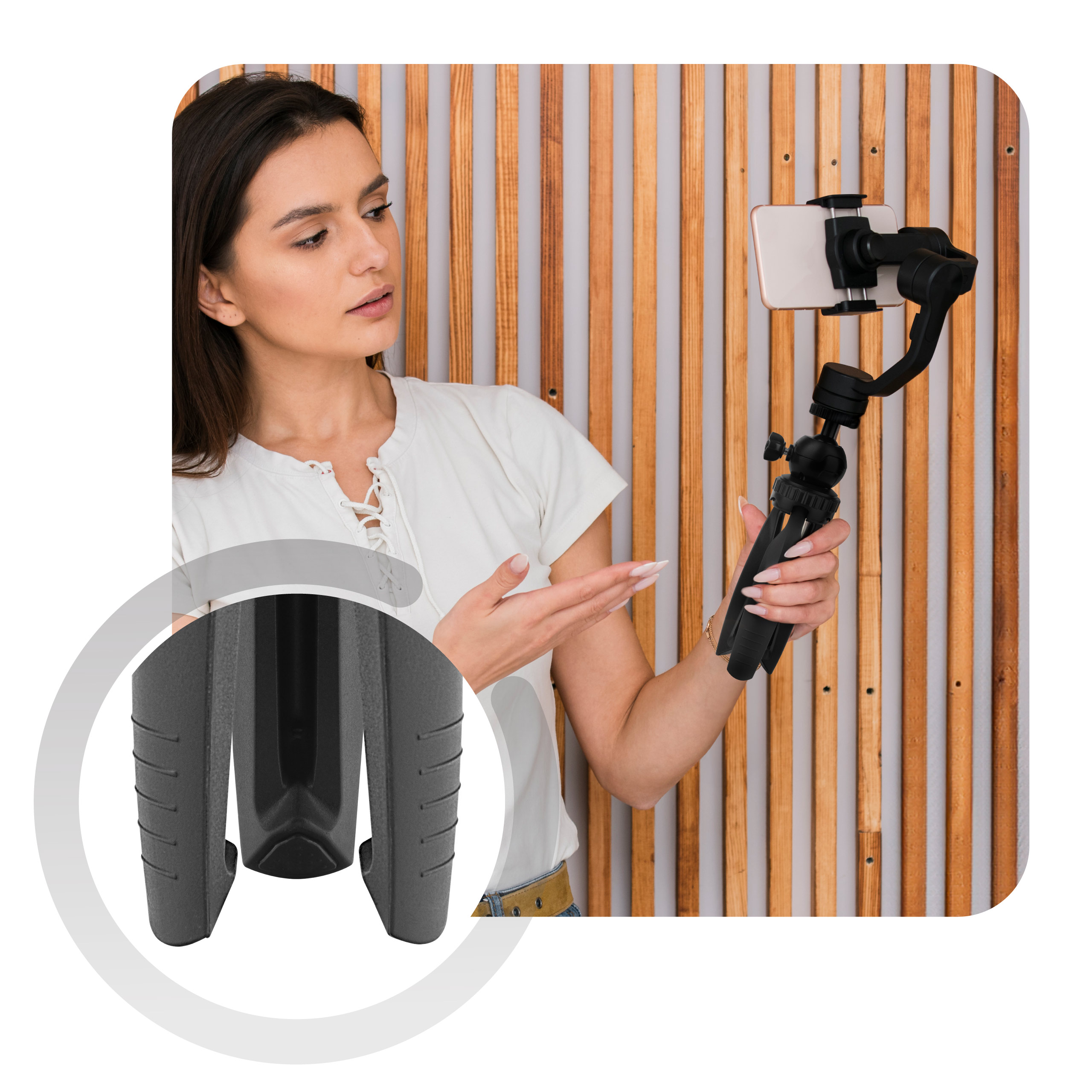 A woman holding a phone on a tripod, filming, with a wooden background.