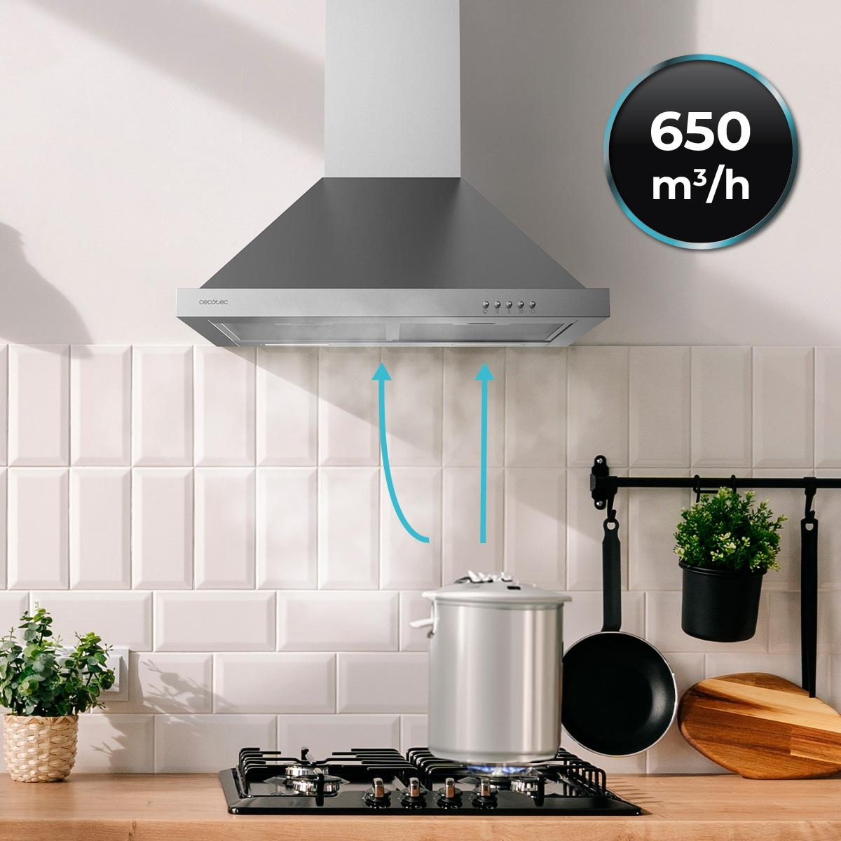 Cocina con campana extractora, estufa, olla y planta. Flechas indican el flujo de aire. La campana tiene 650 m3/h de capacidad.