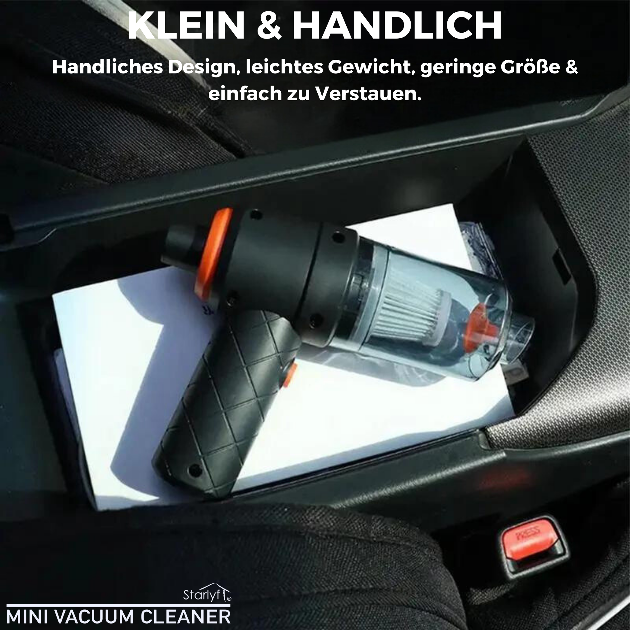 Ein Mini-Staubsauger im Ablagefach eines Autos, neben einem weißen Papier.