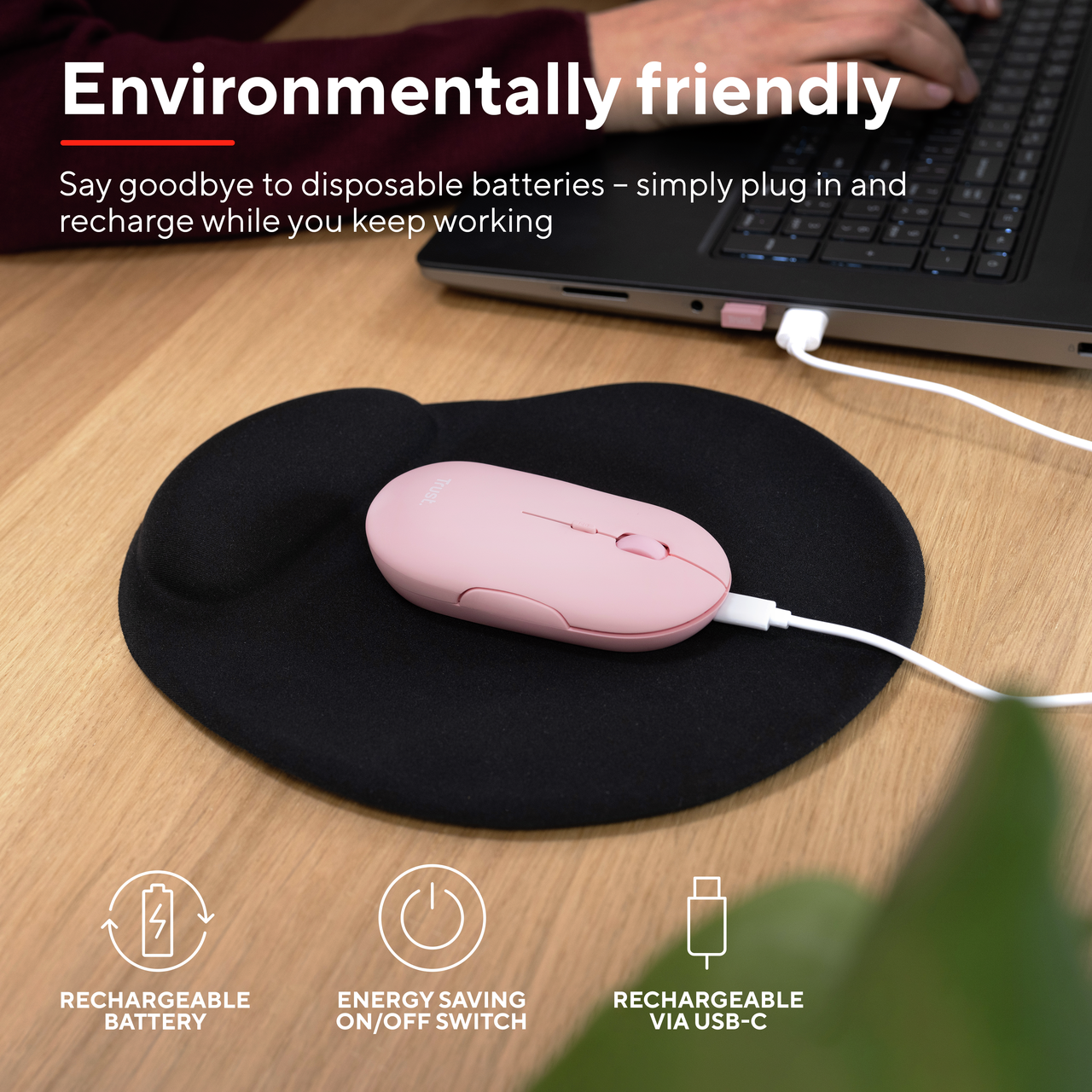Een roze draadloze muis op een zwart muismatje, aangesloten op een laptop met pictogrammen eronder.