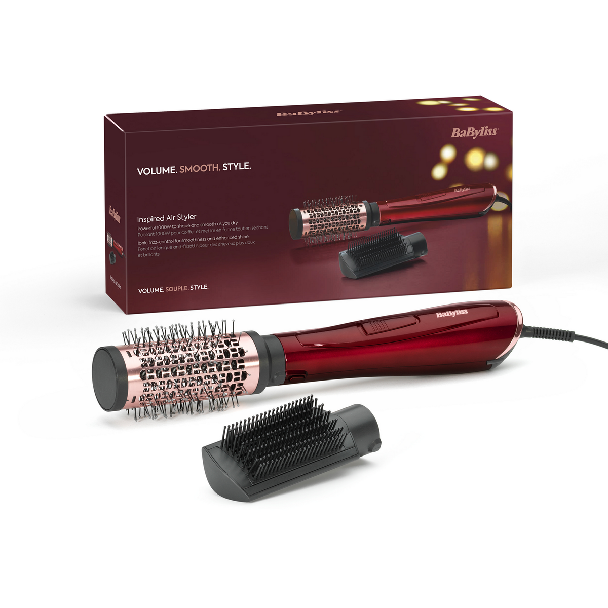 Moldeador de cabello rojo y oro rosa con dos accesorios, en una caja. Superficie blanca.
