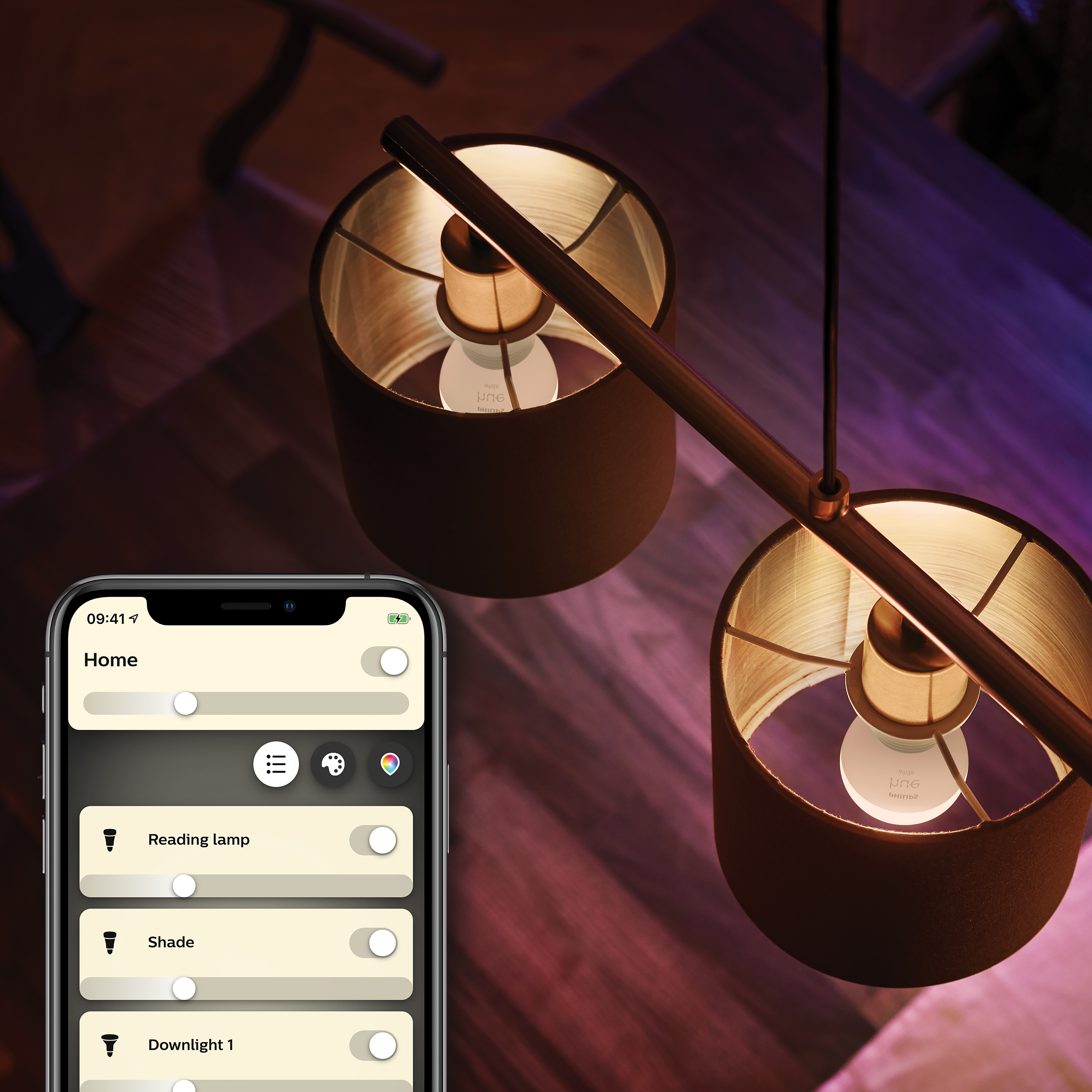 Zwei Lampen mit Schirmen hängen. Ein Telefon mit einer Smart-Home-App befindet sich unten links.