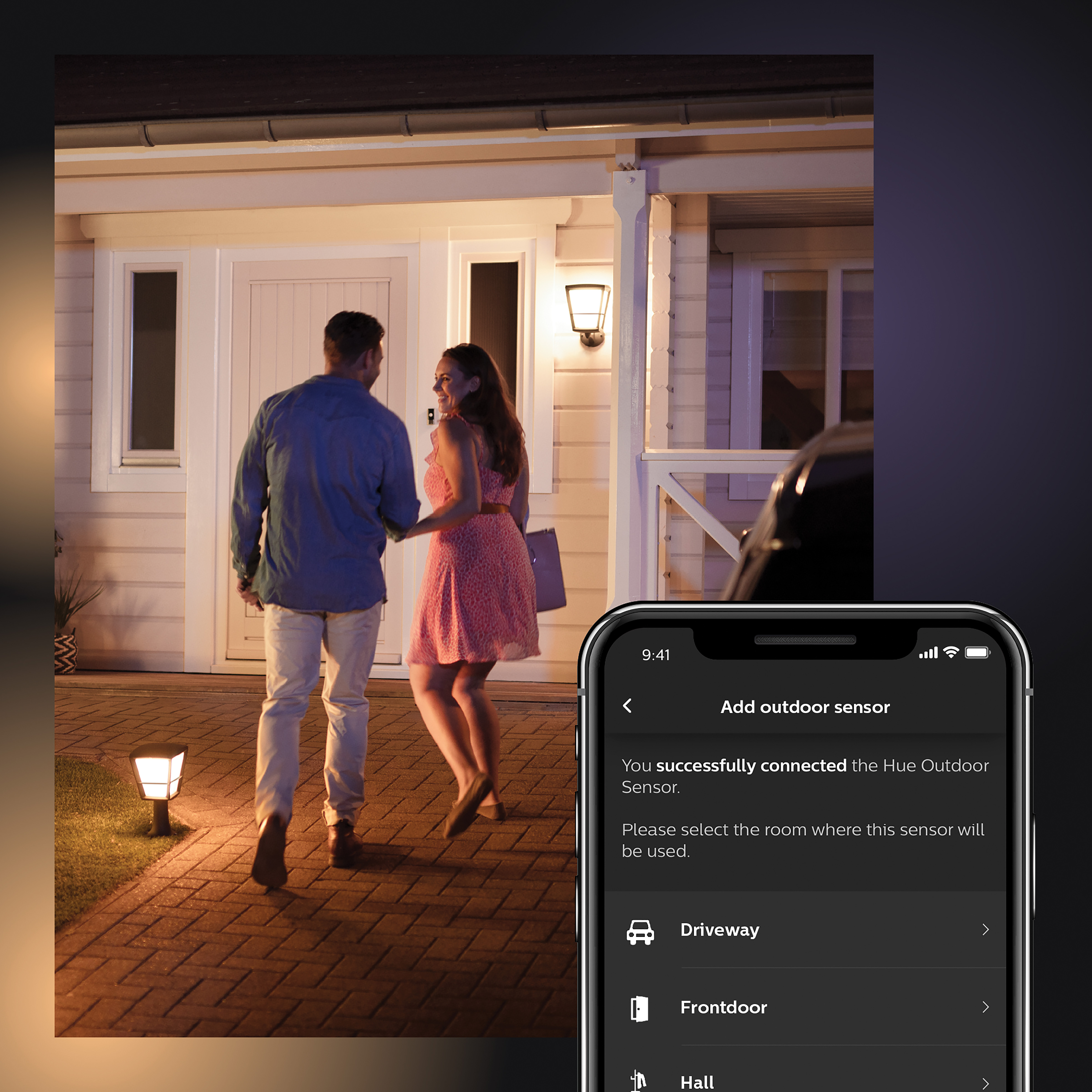 Una coppia che cammina verso una casa con interfaccia smart home su un telefono.