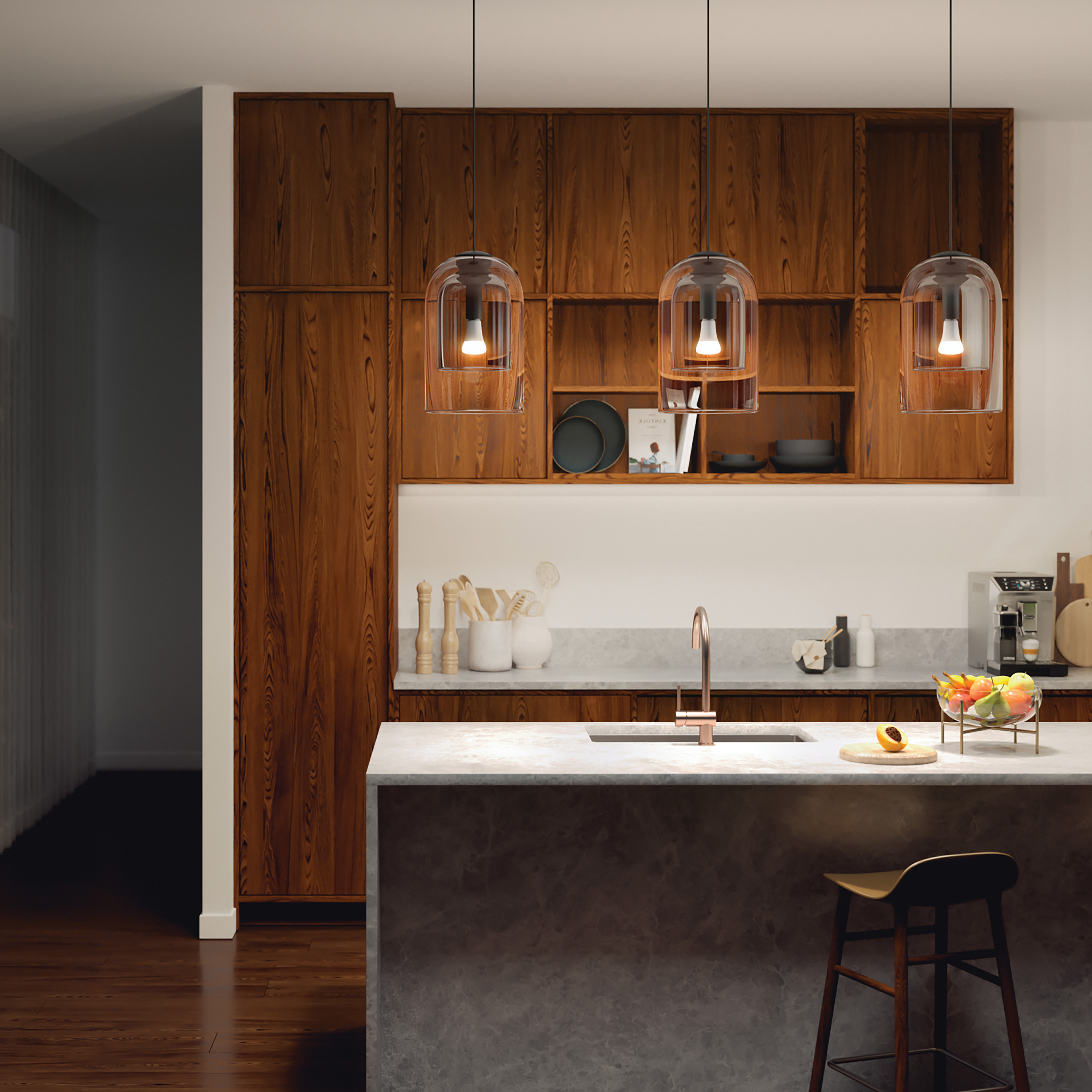 Wnętrze kuchni z trzema lampami wiszącymi, marmurową wyspą i drewnianymi szafkami.