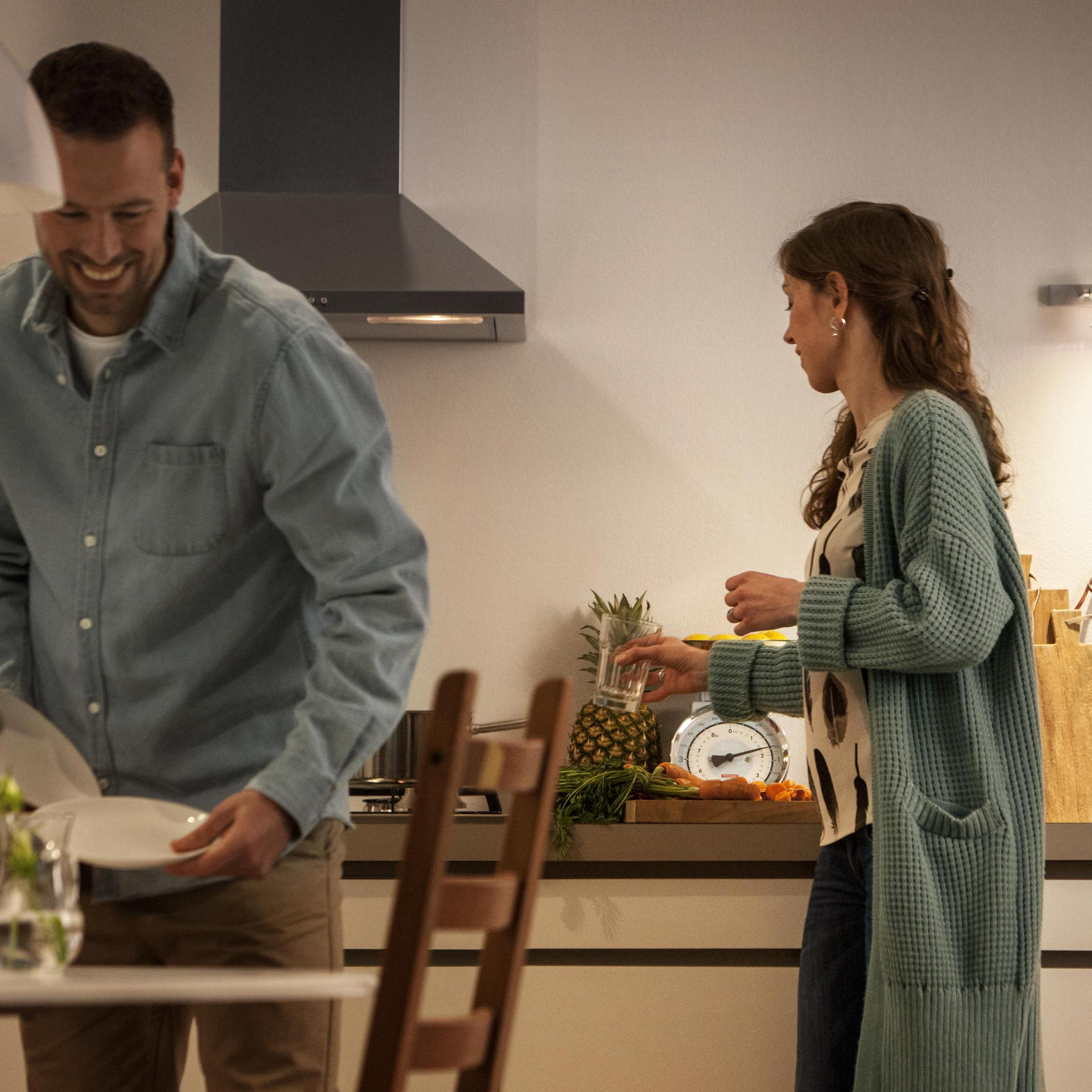 Un couple dans la cuisine préparant de la nourriture.
