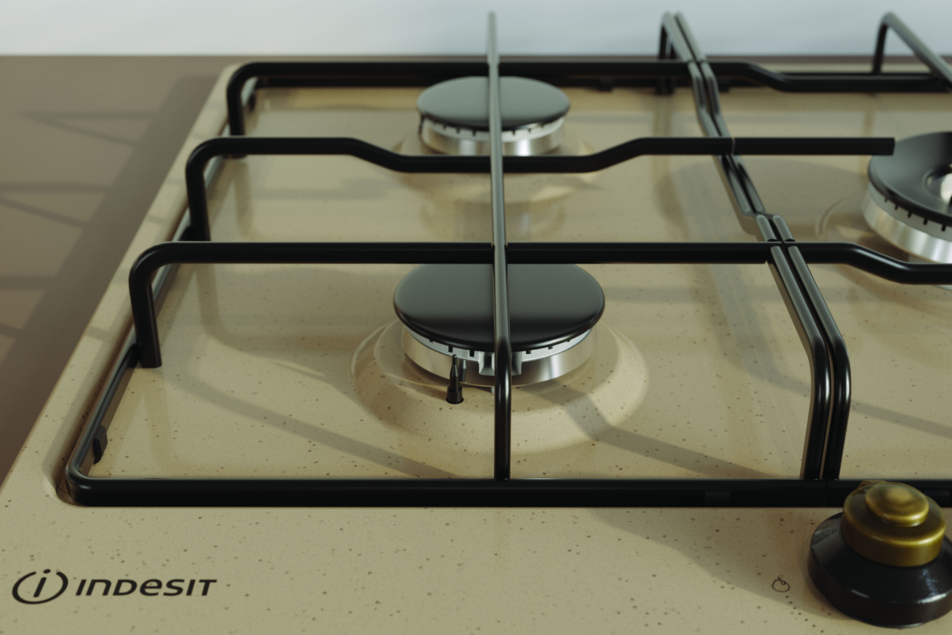 Zbliżenie kuchenki gazowej. Beżowa powierzchnia, czarne palniki i czarne ruszty.