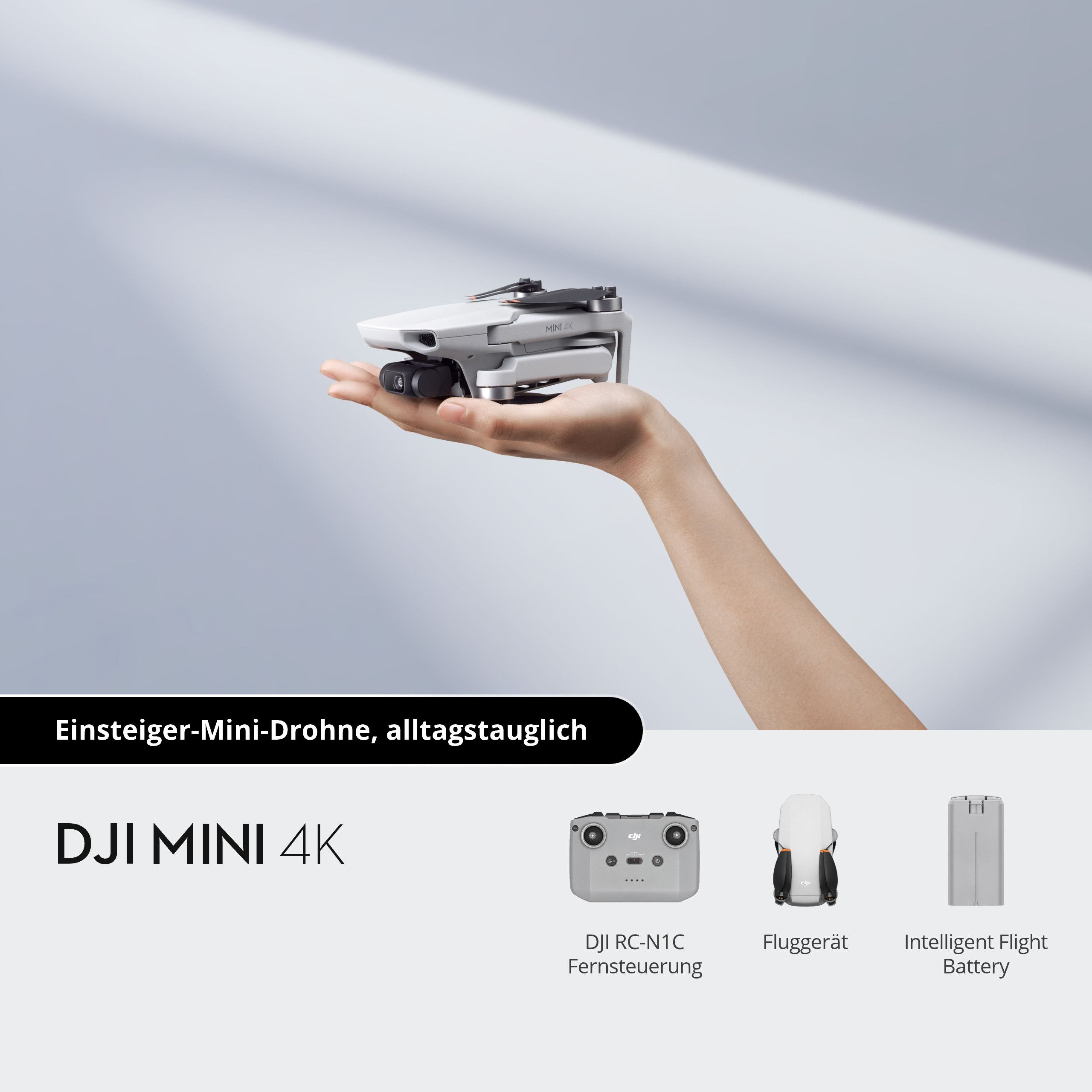 Eine weiße Drohne in einer Hand gehalten mit Text: 'DJI Mini 4K'.
