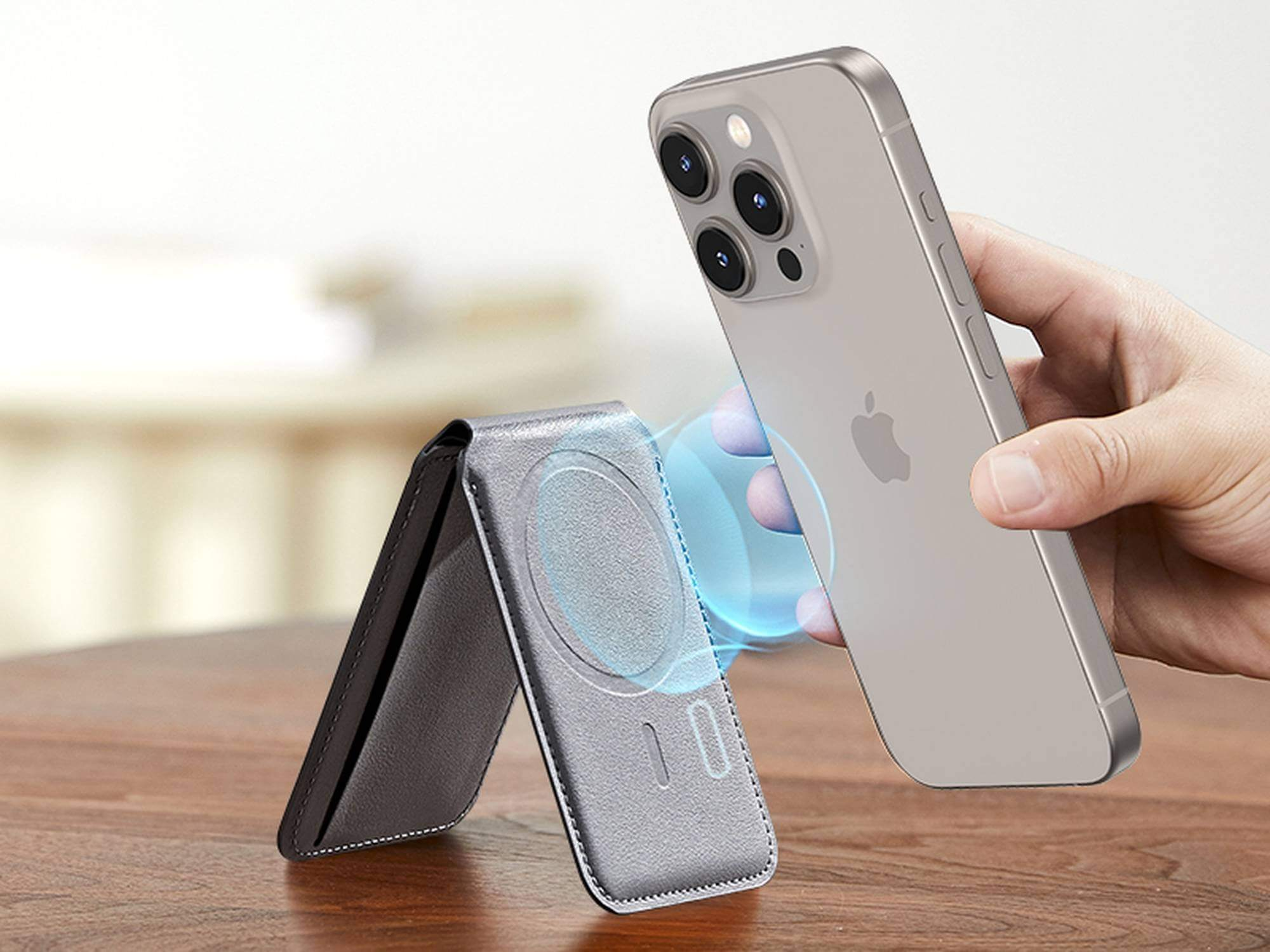 Ein Telefon wird magnetisch an einer Brieftasche befestigt. Das Telefon ist silberfarben, die Brieftasche dunkelgrau.