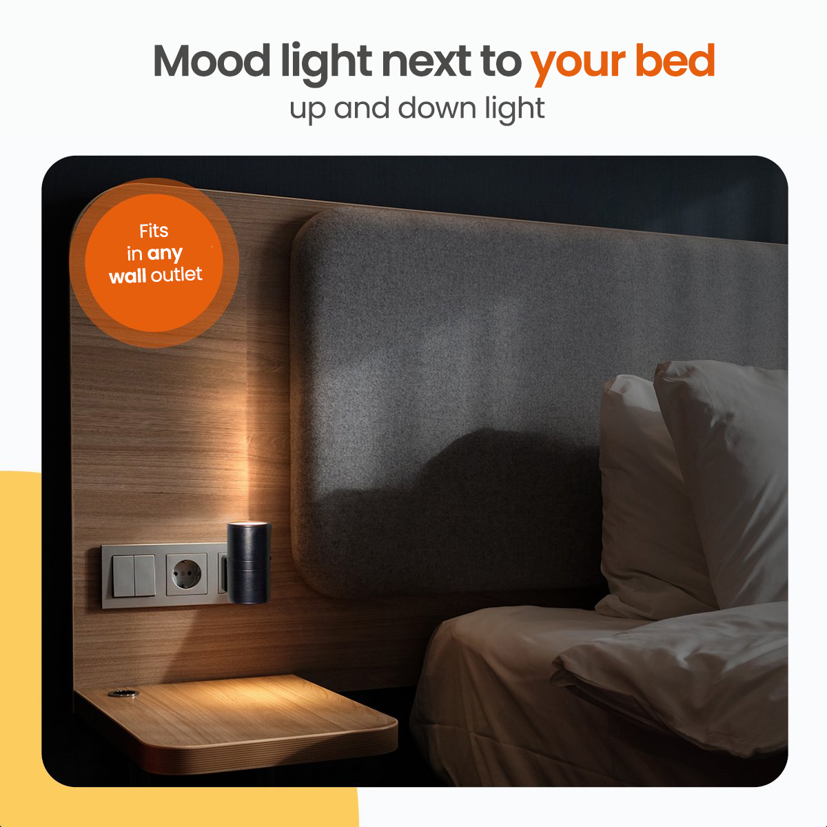 Mood light next to a bed. Black, cylindrical lamp on a wooden nightstand with a plug.