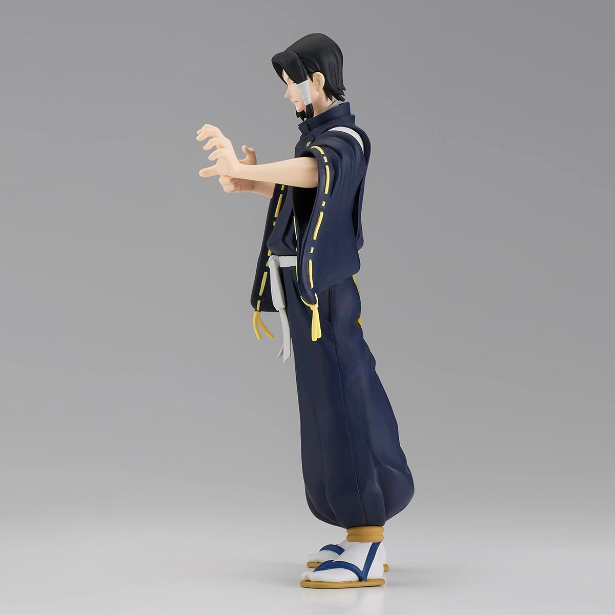 Anime-Figur eines Mannes in dunkelblauer Kleidung, Seitenansicht, Arme ausgestreckt, mit Verband.