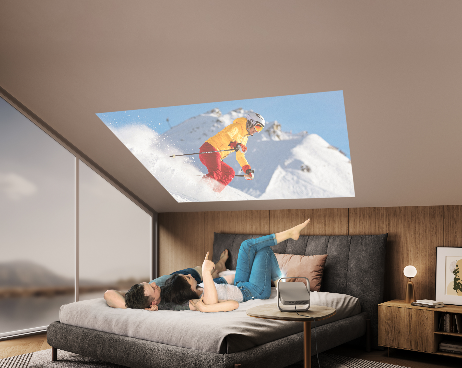 Para leżąca na łóżku oglądająca wyświetlany obraz narciarza na zaśnieżonej górze.