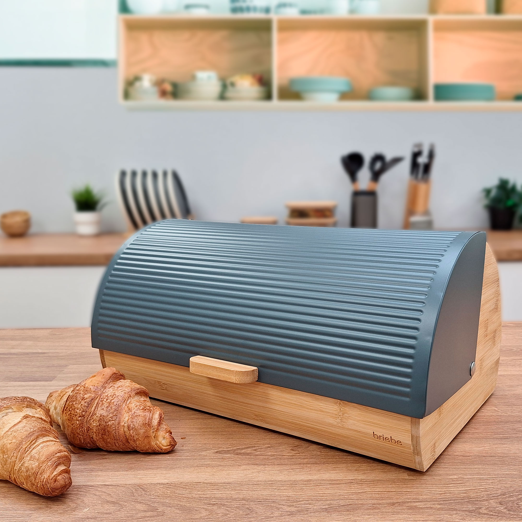 Una panera con cruasanes sobre una encimera de madera, con un fondo de cocina.