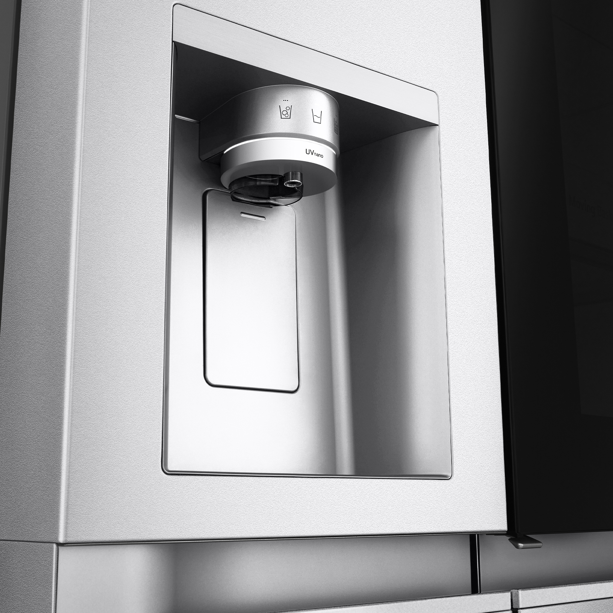 Dispensador de agua de acero inoxidable de un refrigerador. Vista de cerca. El dispensador es plateado.