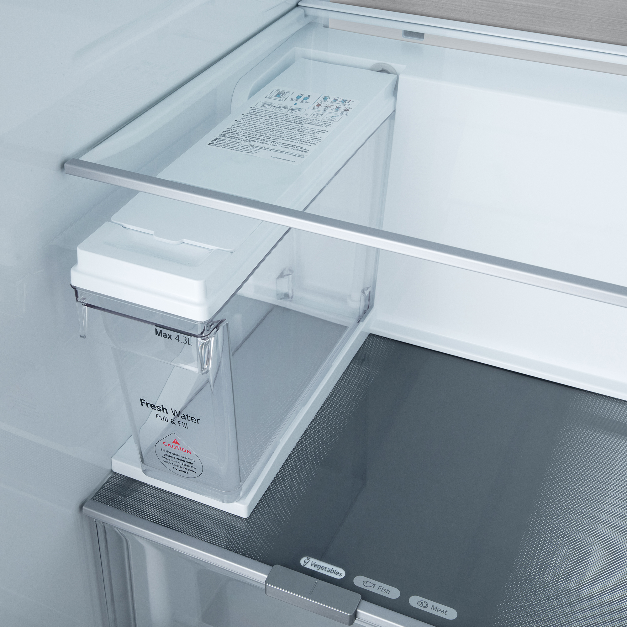 Un dispensador de agua de refrigerador. El tanque de agua es transparente con tapa blanca. Está dentro del refrigerador.