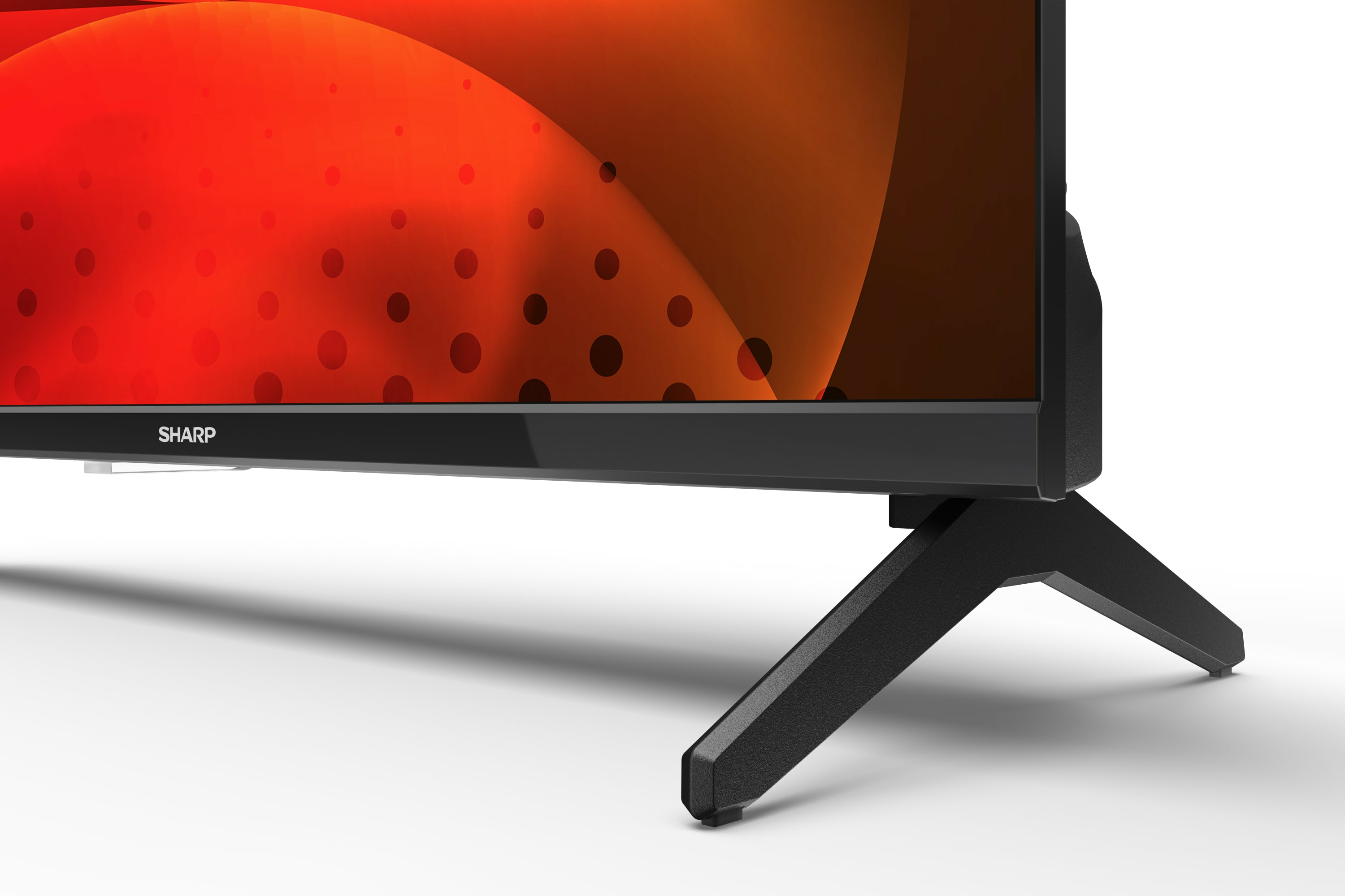 Czarny telewizor z logo Sharp, czarne nogi, czerwone i pomarańczowe tło abstrakcyjne.
