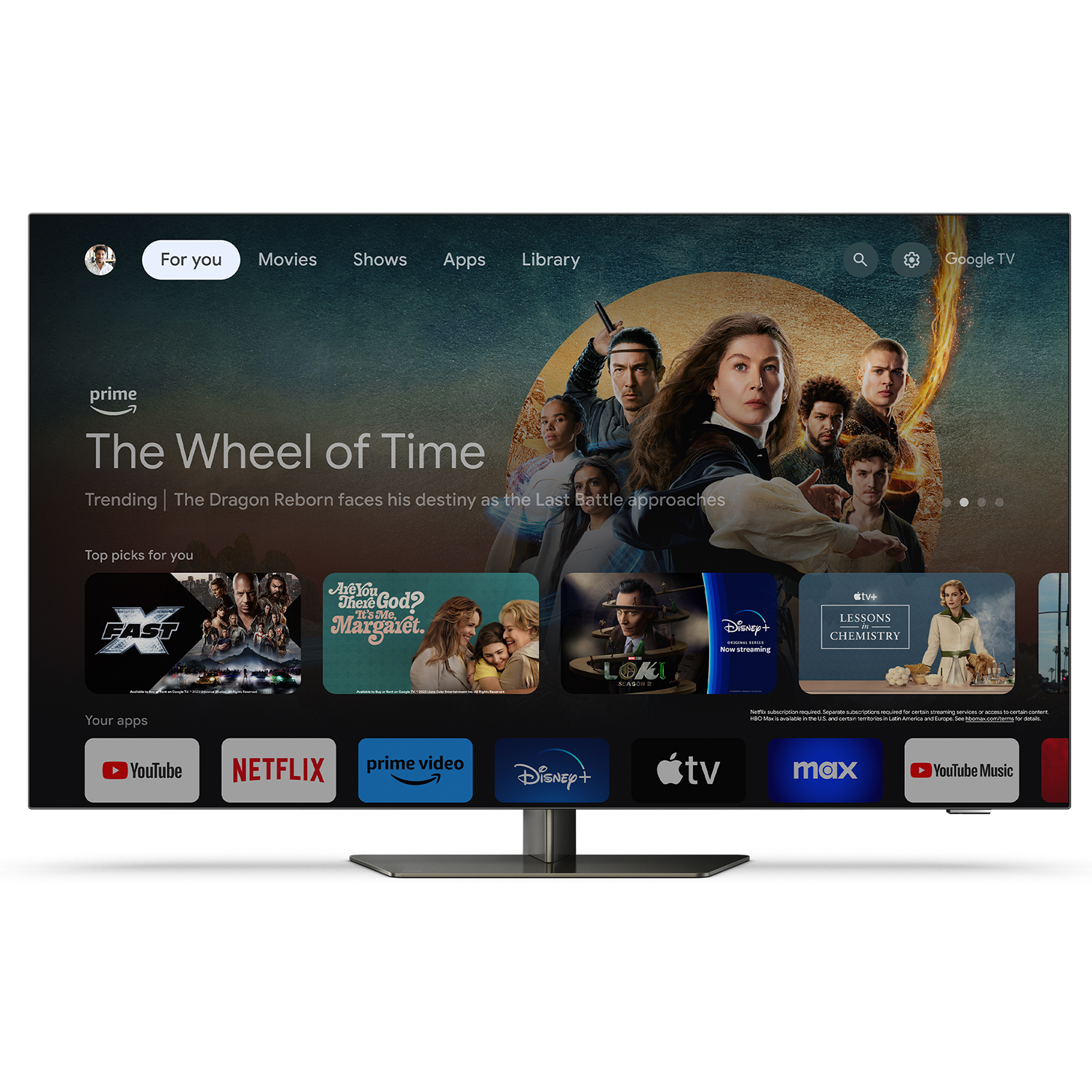 Ein Fernseher zeigt eine Streaming-Dienst-Oberfläche. Hintergrund: schwarzer Ständer und weiße Wand.