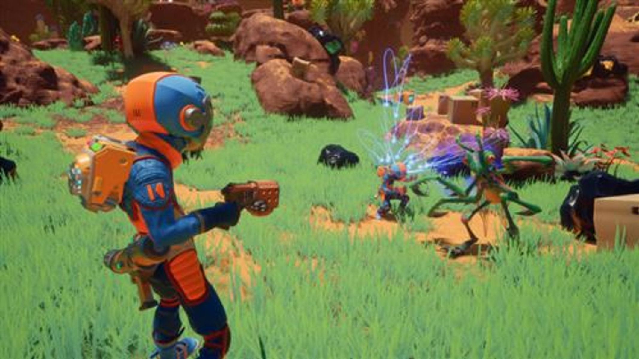Scena z gry wideo przedstawiająca osobę strzelającą z broni w kierunku dwóch stworzeń przypominających kosmitów w trawiastym, pustynnym otoczeniu.