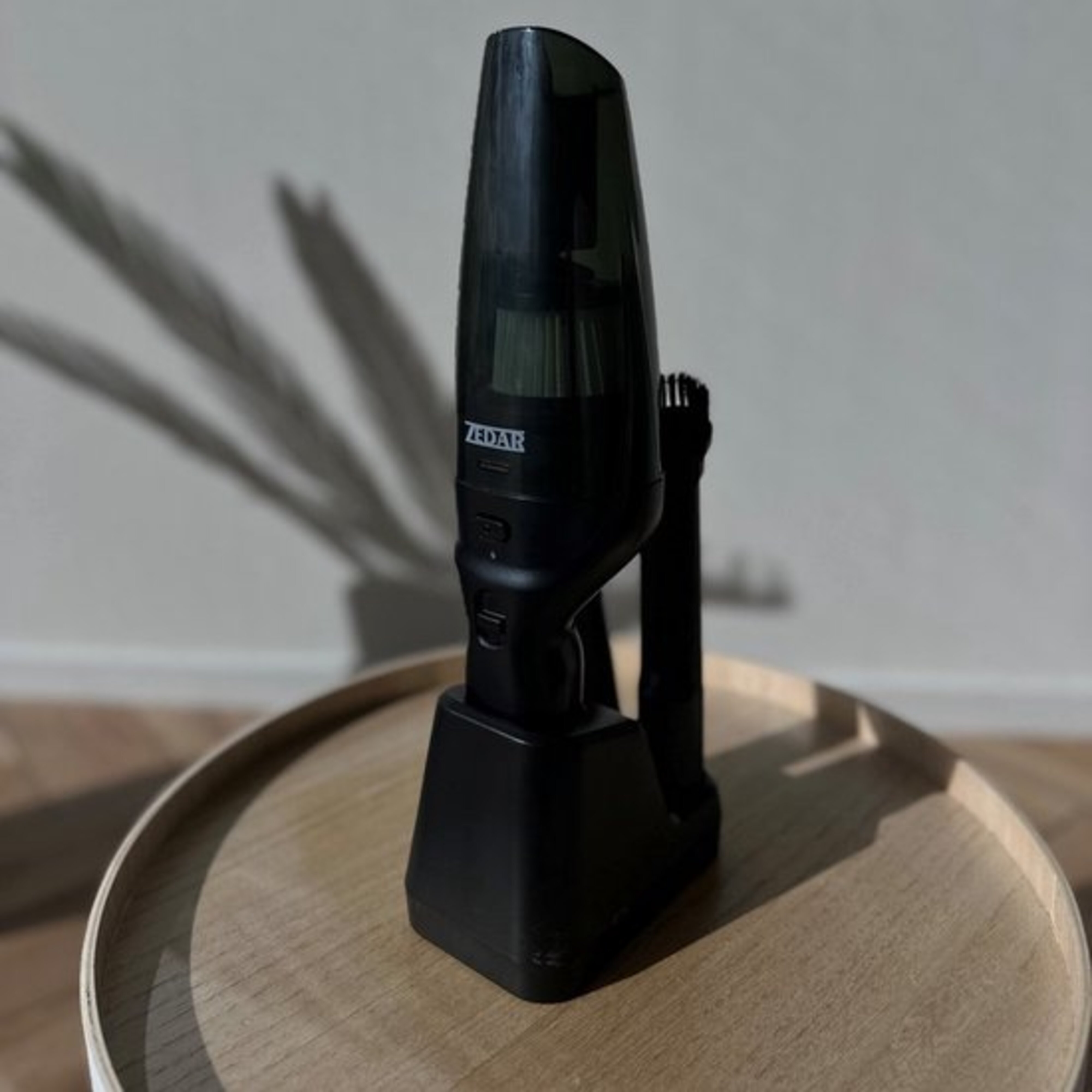 A black handheld vacuum cleaner on a table.