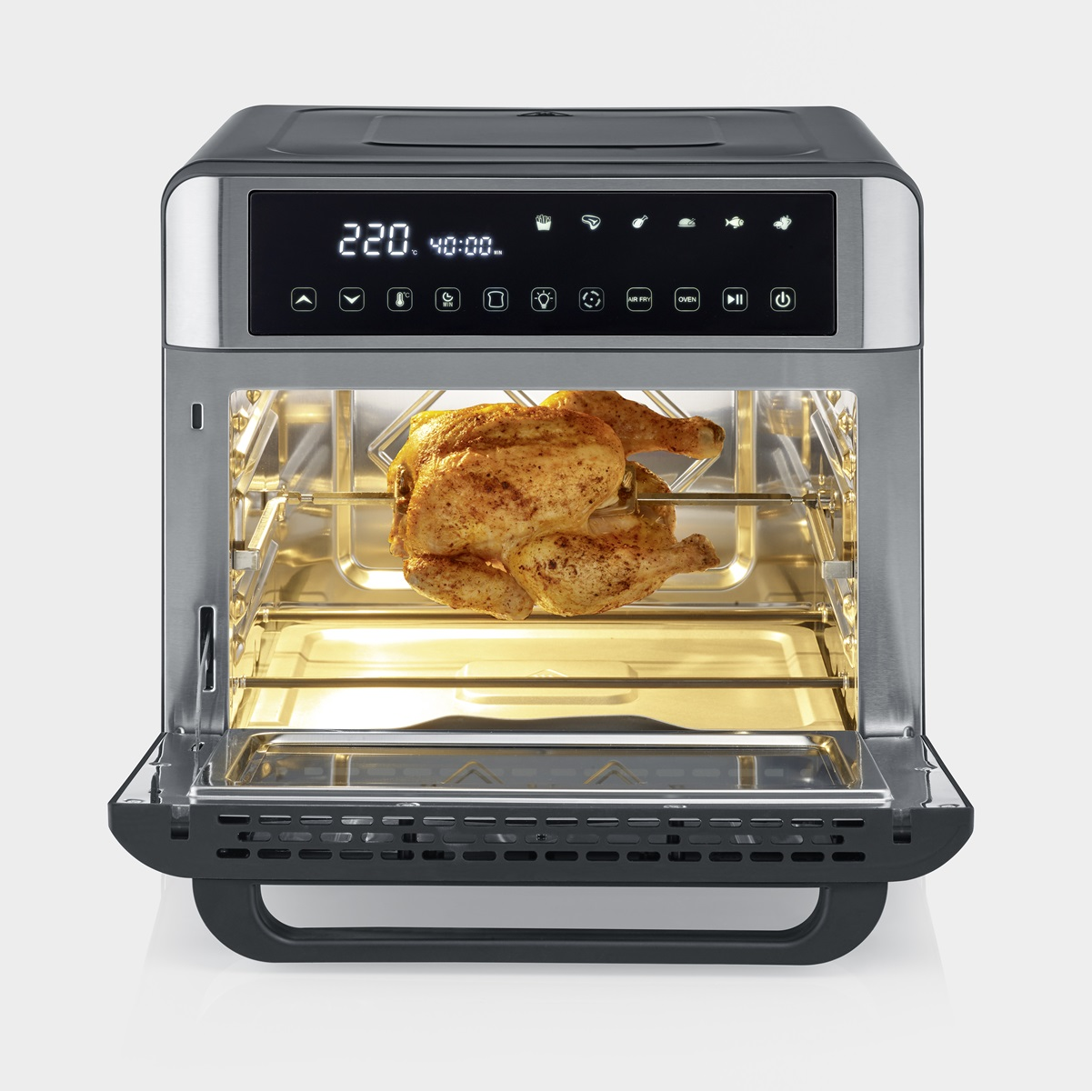 Een airfryer met een gekookte kip erin. De deur staat open, de kip is zichtbaar.