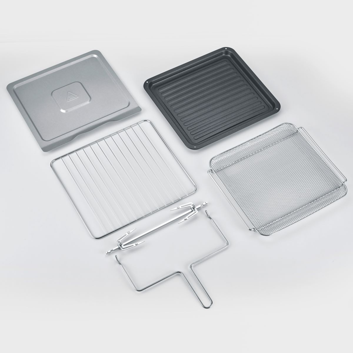 Diverse accessoires voor de airfryer, waaronder bakplaten en een draaispit, netjes gerangschikt.