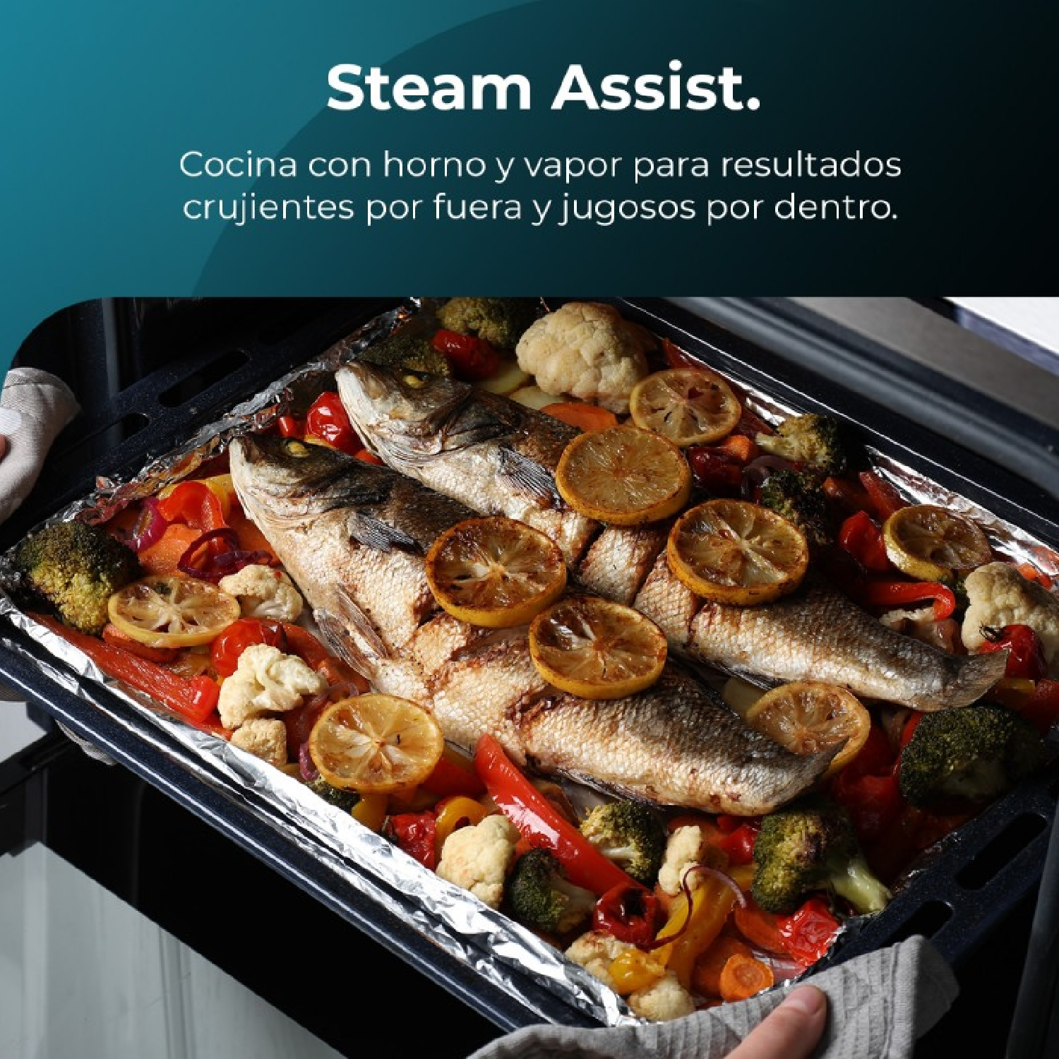Horno con pescado y verduras. Pescado cubierto con rodajas de limón. Brócoli, zanahorias y pimientos rojos visibles.