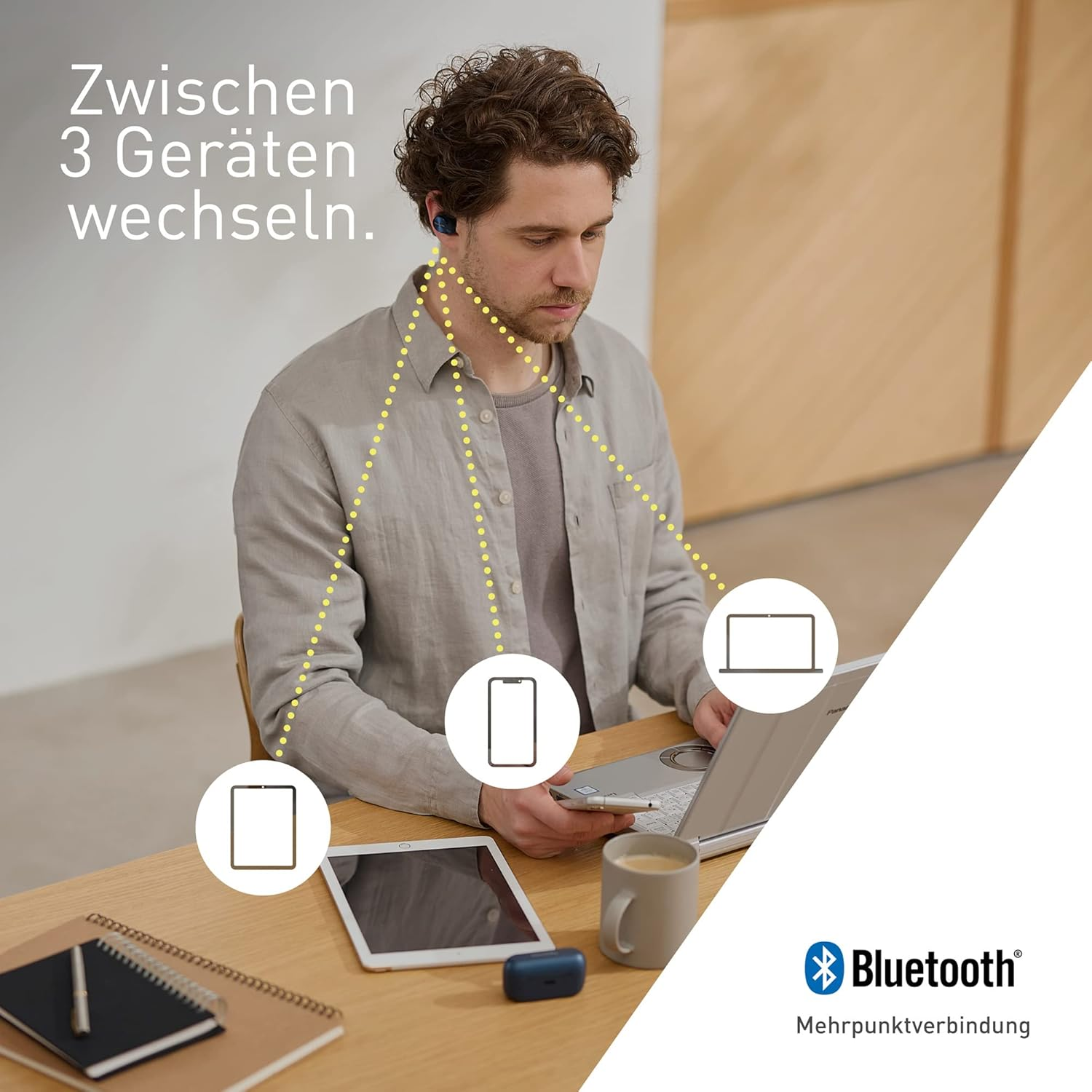 Ein Mann benutzt Ohrhörer, verbunden mit Tablet, Telefon und Laptop. Text gibt an, zwischen 3 Geräten zu wechseln.