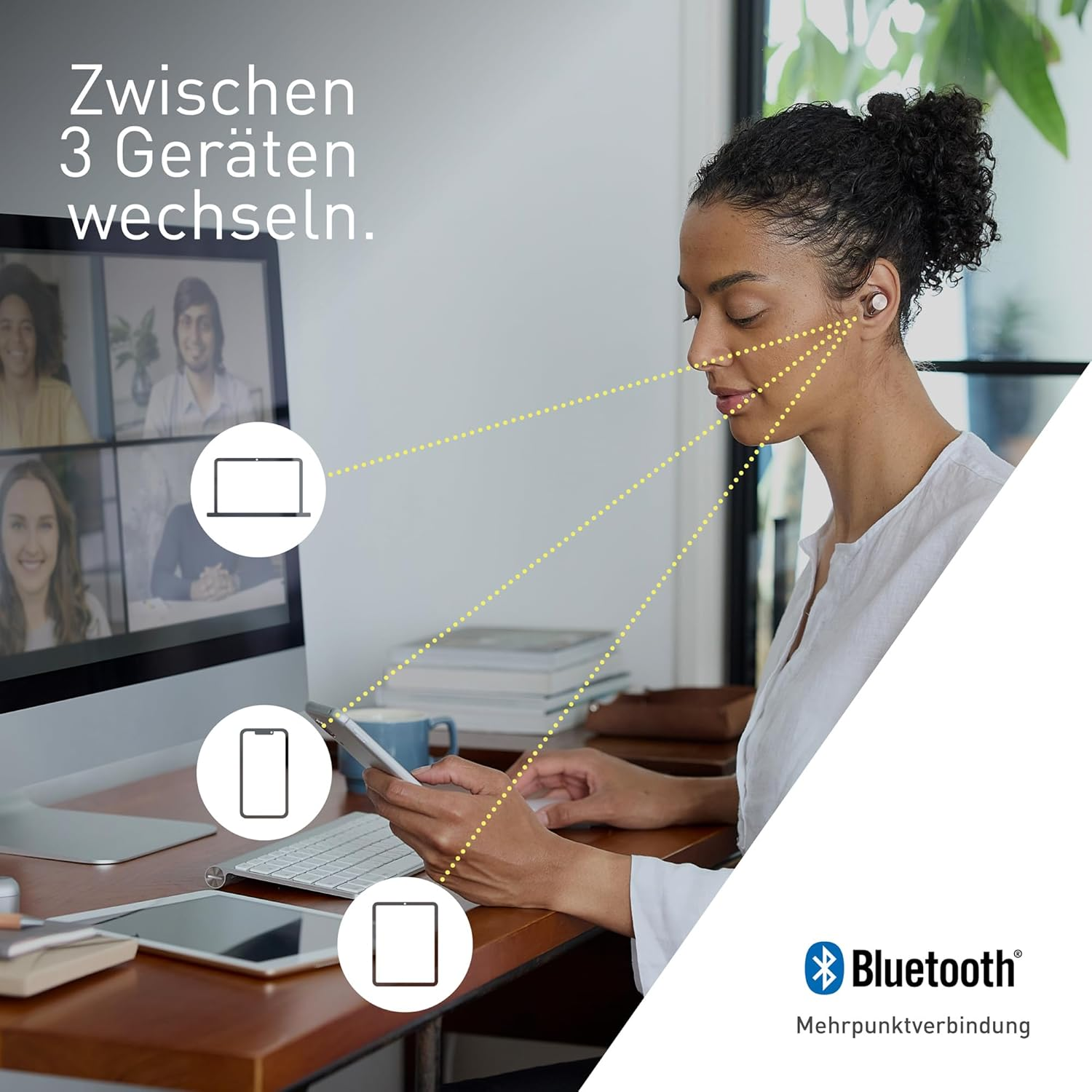 Frau, die Bluetooth-Ohrhörer verwendet und mit mehreren Geräten auf einem Schreibtisch interagiert.