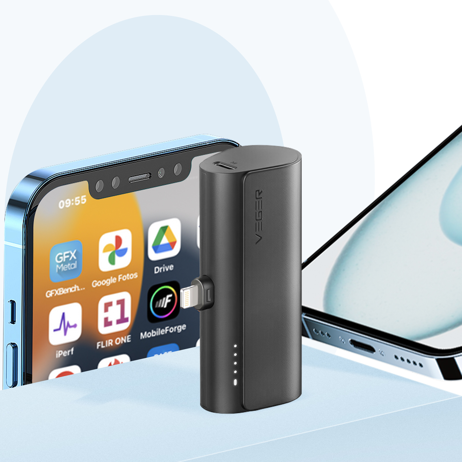 Ein schwarzes tragbares Ladegerät steht neben zwei Telefonen. Ein Telefon zeigt App-Symbole an.