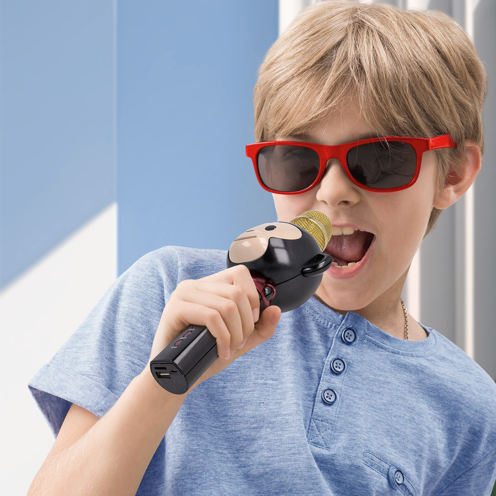 Ein Junge mit roter Sonnenbrille singt in ein Mikrofon.