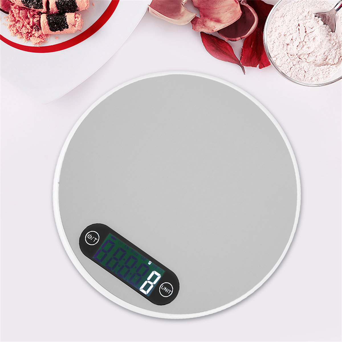 Digitale Waage mit weißem Rand. Schüssel mit Mehl und Essen an der Seite. Draufsicht.