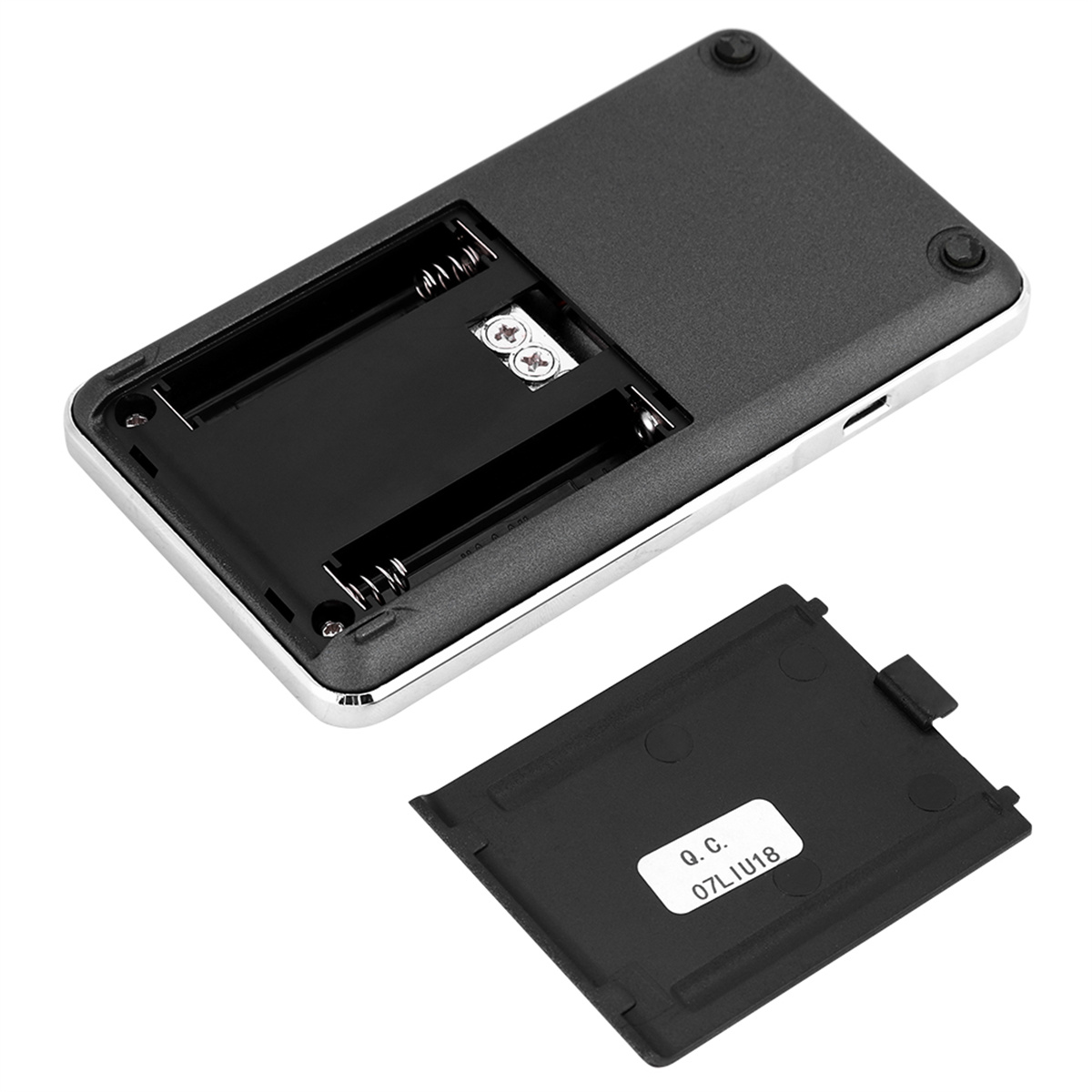 Rückseite einer kleinen schwarzen Waage, Batteriefach geöffnet. Zwei Batterien sichtbar.
