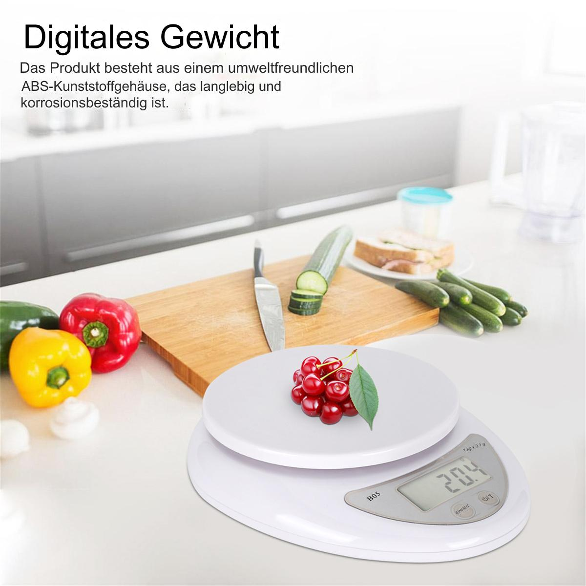 Eine weiße digitale Küchenwaage mit roten Kirschen, Paprika und einem Messer darauf.