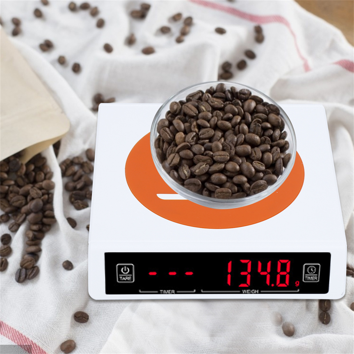 Nahaufnahme einer digitalen Küchenwaage mit Kaffeebohnen in einer Glasschüssel. Das Display zeigt 134,8.