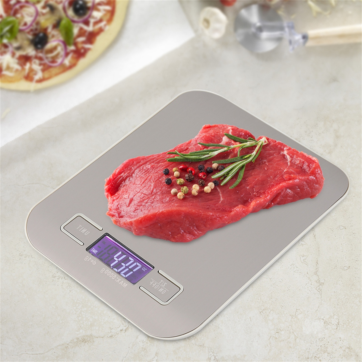 Ein rohes Steak mit Gewürzen auf einer digitalen Küchenwaage, Pizza im Hintergrund.