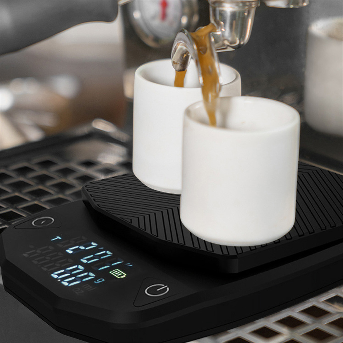 Espressomaschine, die Kaffee in zwei weiße Tassen auf einer schwarzen Digitalwaage gießt.
