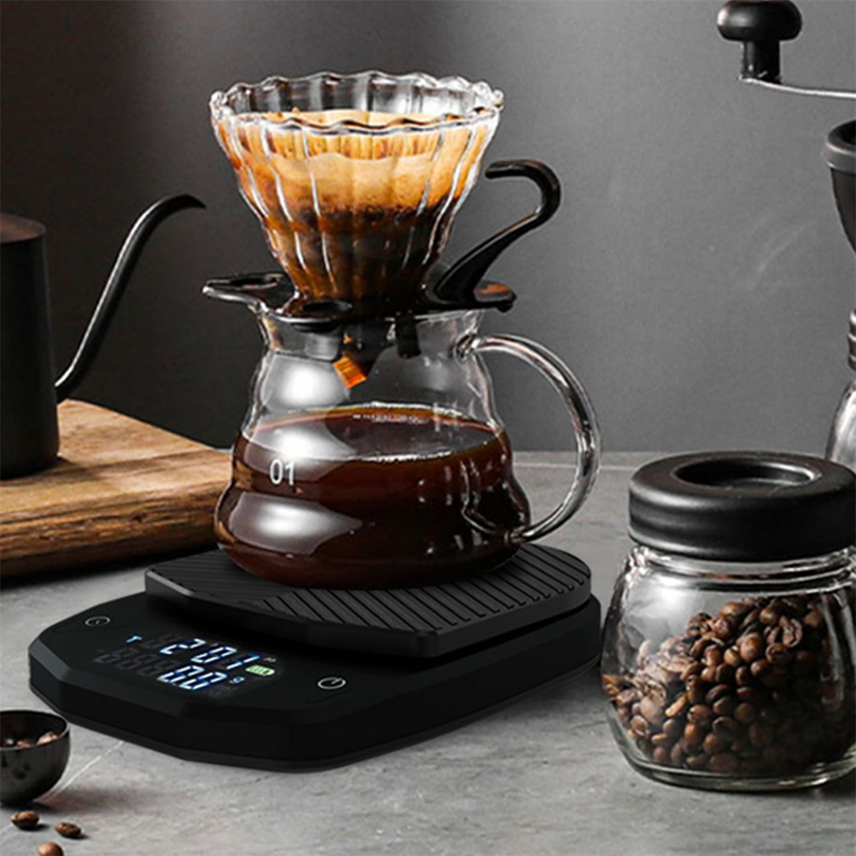 Ein Kaffee-Setup mit Glas-Pour-Over, Waage, Bohnenglas und Schwanenhalskessel.