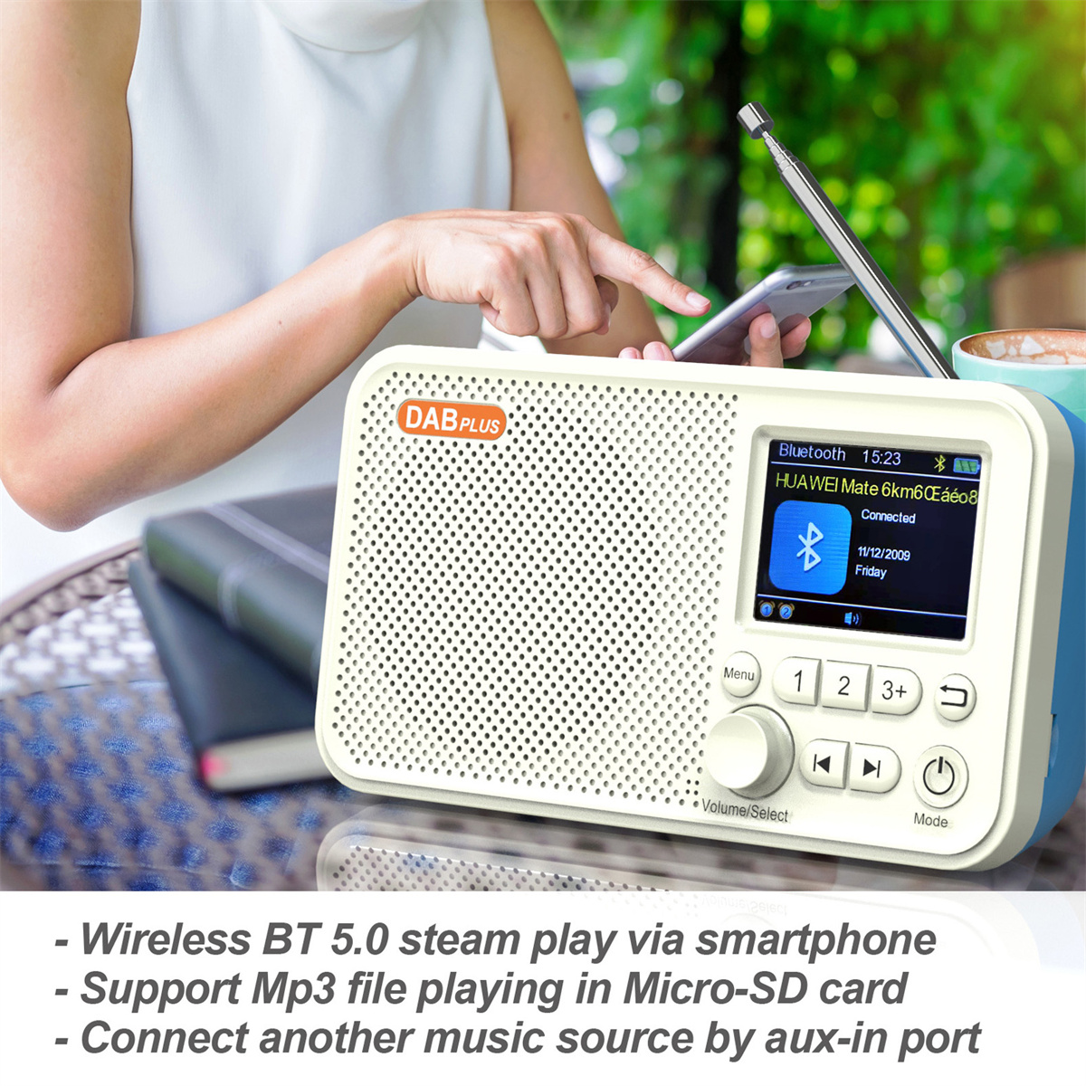 Eine Person hält ein weiß-blaues DAB-Radio. Display zeigt Zeit, Bluetooth und Datum.