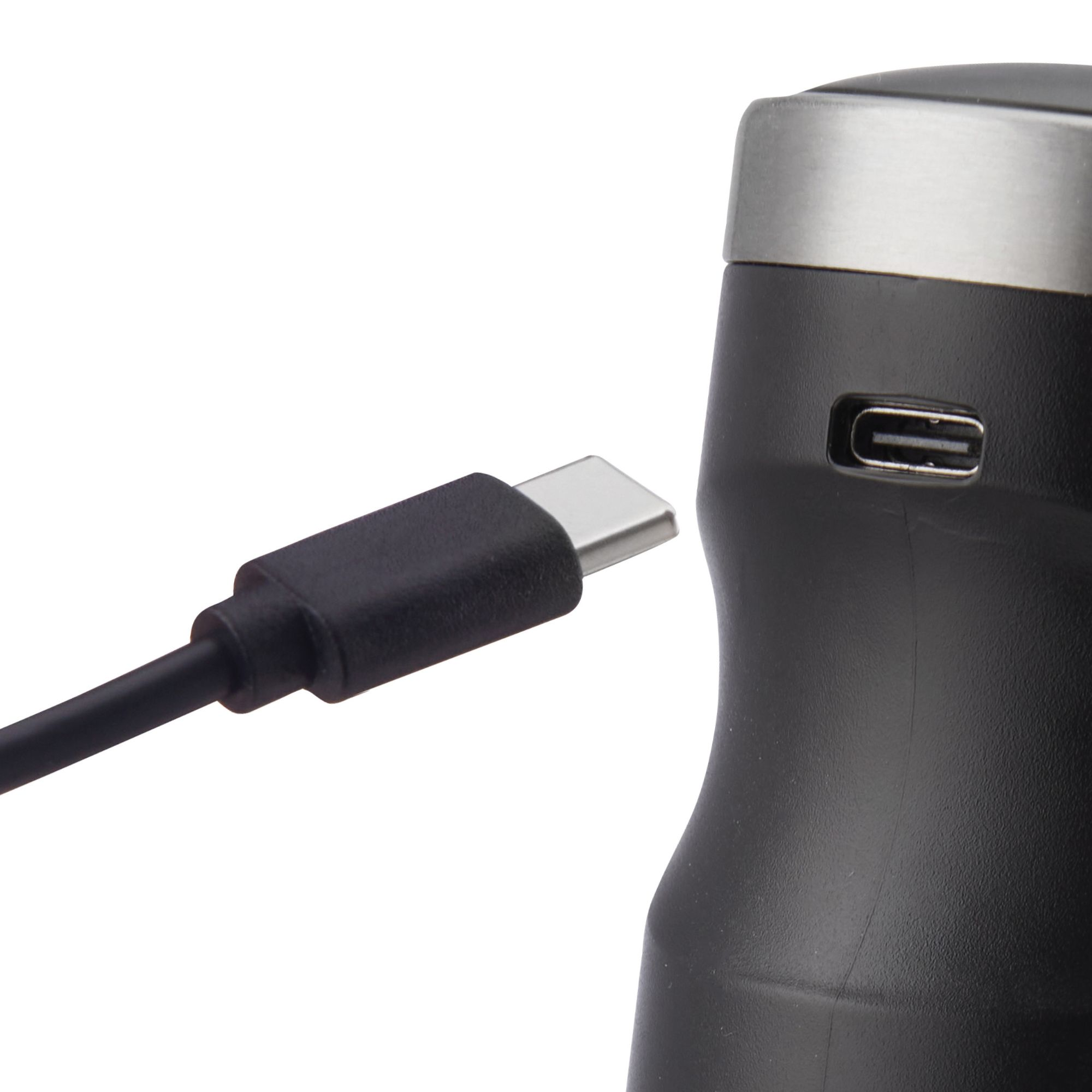 Schwarzes Kabel mit USB-C-Anschluss, der in ein schwarzes Gerät mit silberner Oberseite gesteckt ist.