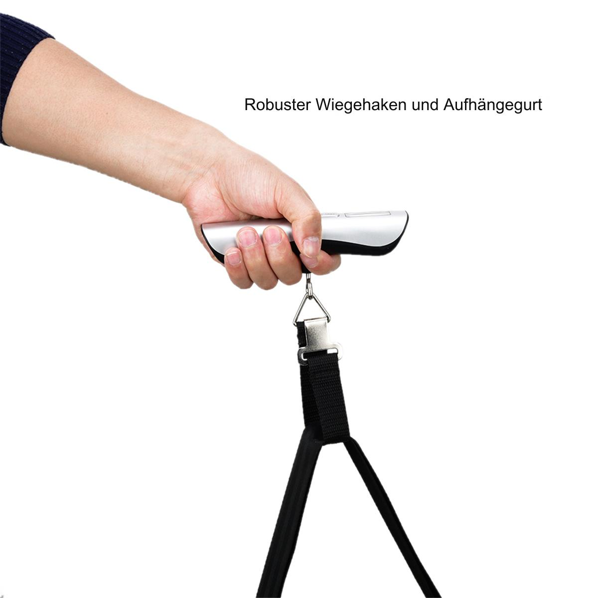 Eine Person hält eine silberne Gepäckwaage an ihrem Griff, mit schwarzem Gurt.