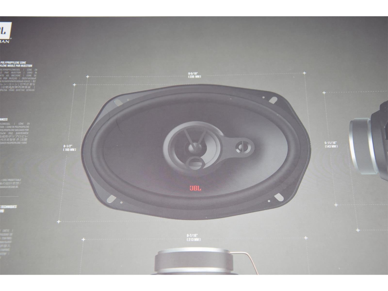 Un haut-parleur avec le logo JBL et un graphique des dimensions sur fond gris.