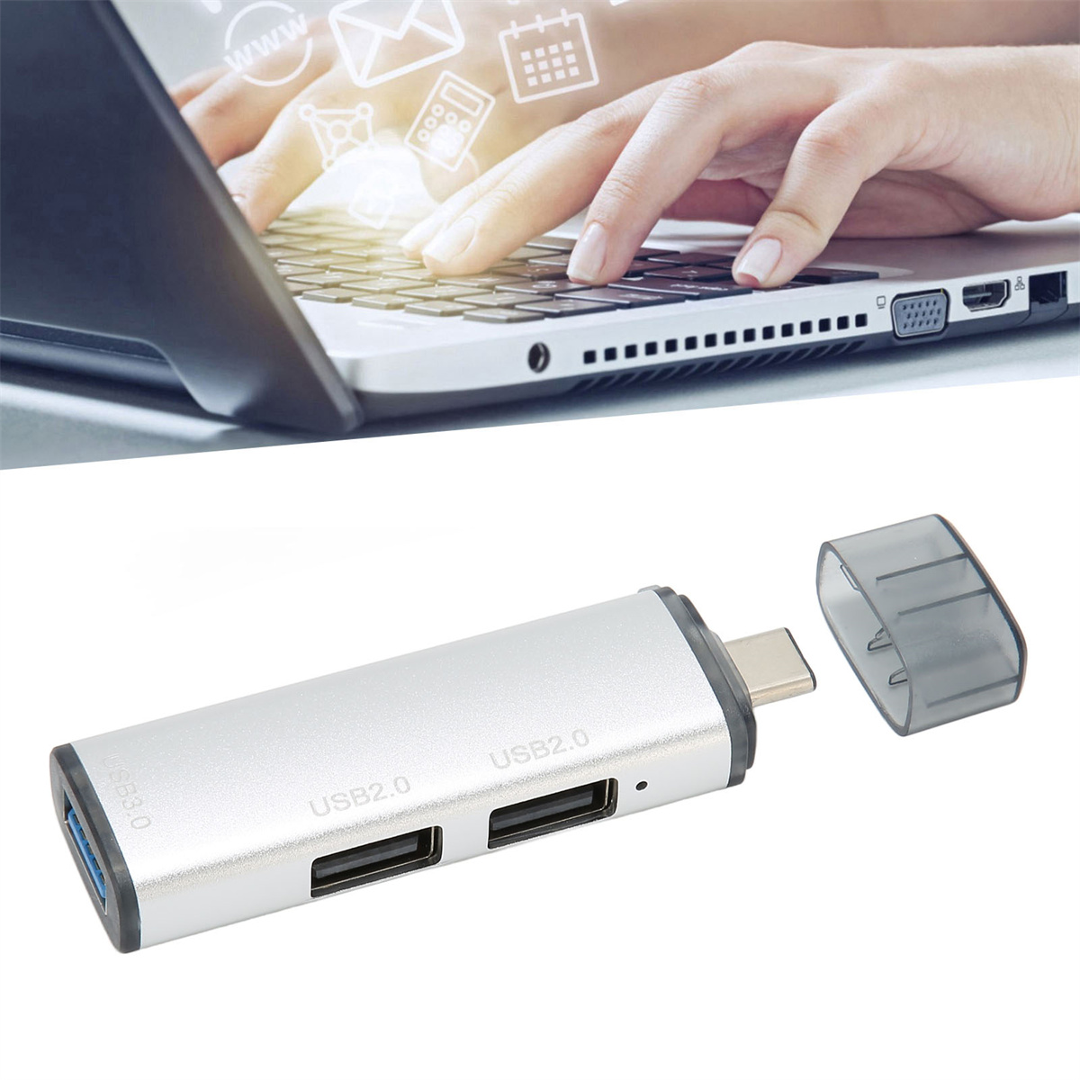 Eine Hand, die einen Laptop benutzt, und ein silberner USB-Hub mit USB-Anschlüssen. Der Hub hat eine Kappe.