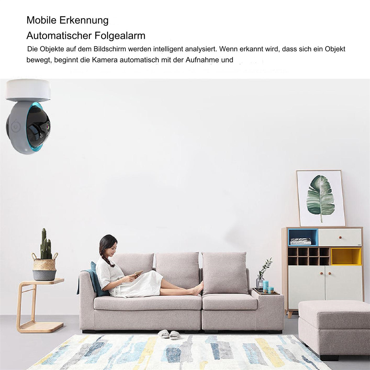 Eine Überwachungskamera ist an einer weißen Wand montiert. Eine Frau sitzt auf einem Sofa und schaut auf ein Telefon.